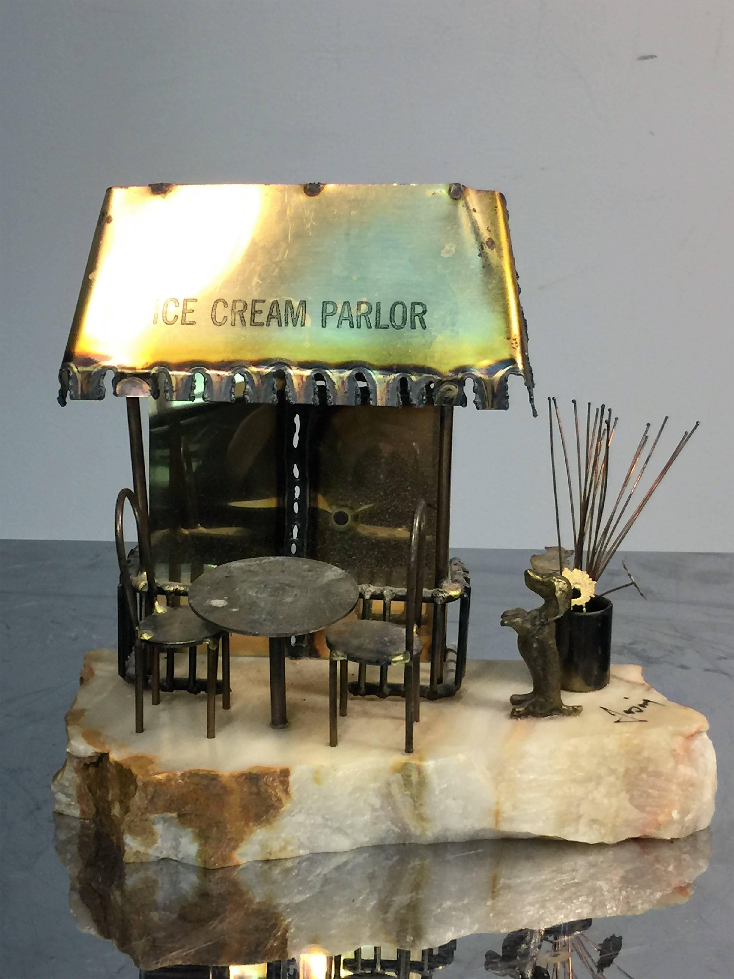 Adorable 1970s mixed metals ice cream parlor with begging dog, cafe table and chairs and plant in pot. Signed in black script jasing.
