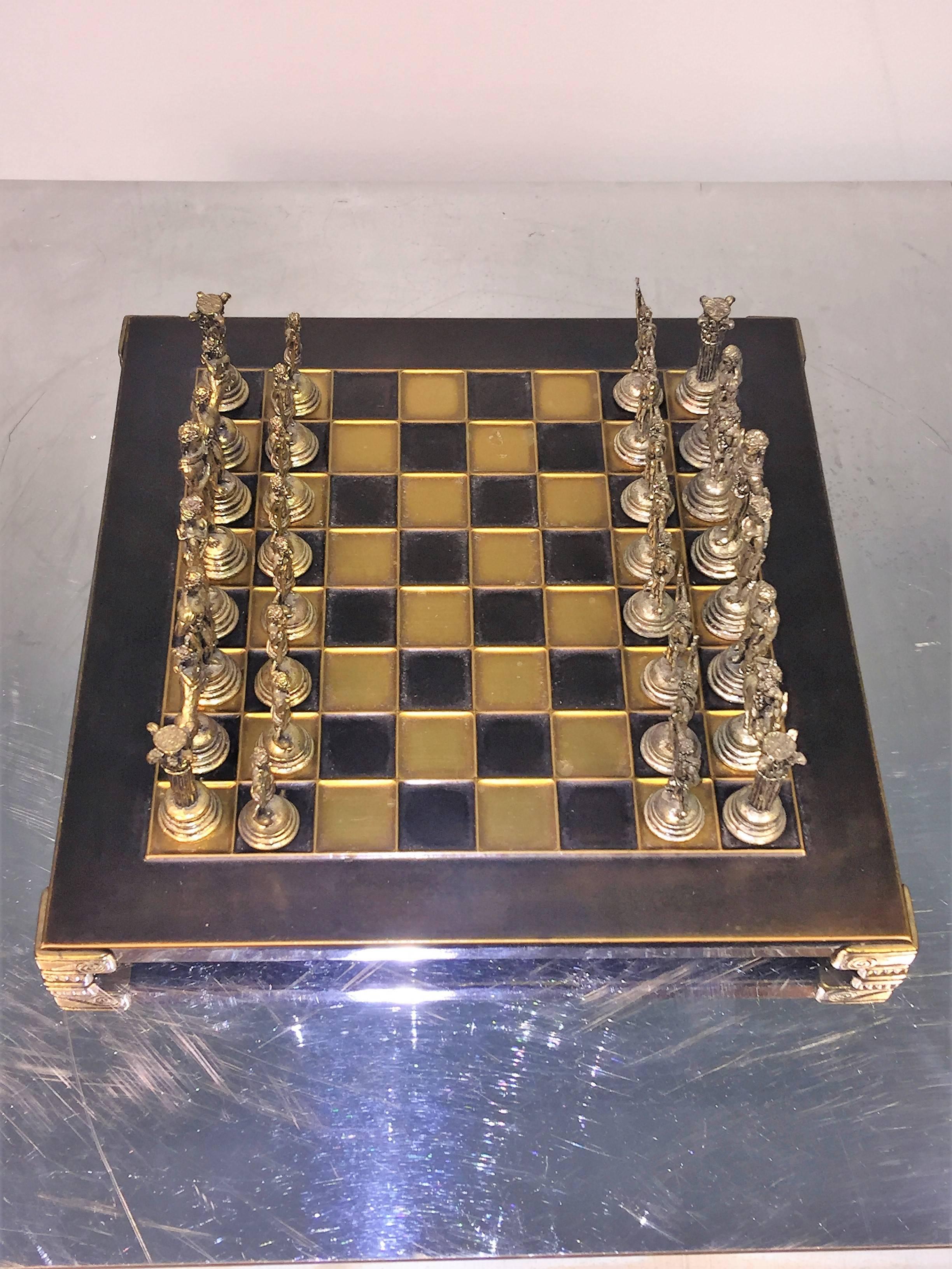 Great cast metal chess pieces in antiqued silver and brass on two-tone chess board. The chess board measures at 4