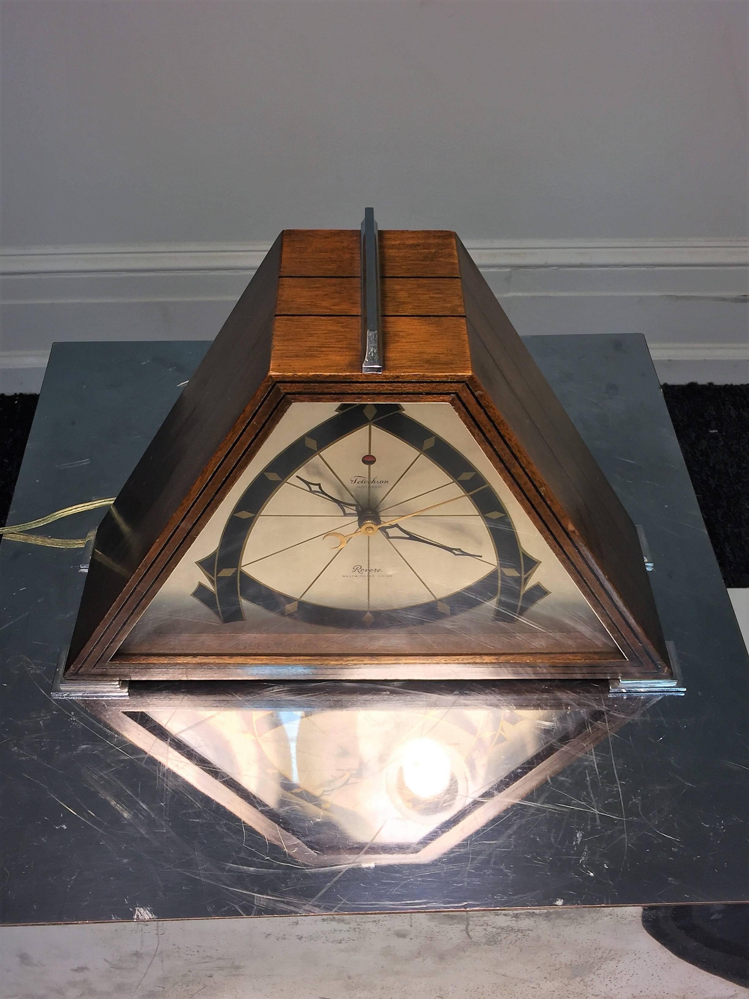 High style interesting silver, black and gold metal faced clock with walnut black inlaid designs. The clock has a stepped chromed bronze crest and stepped skyscraper feet. Chimes in the lovely Westminster chime on the hour. This early electric clock
