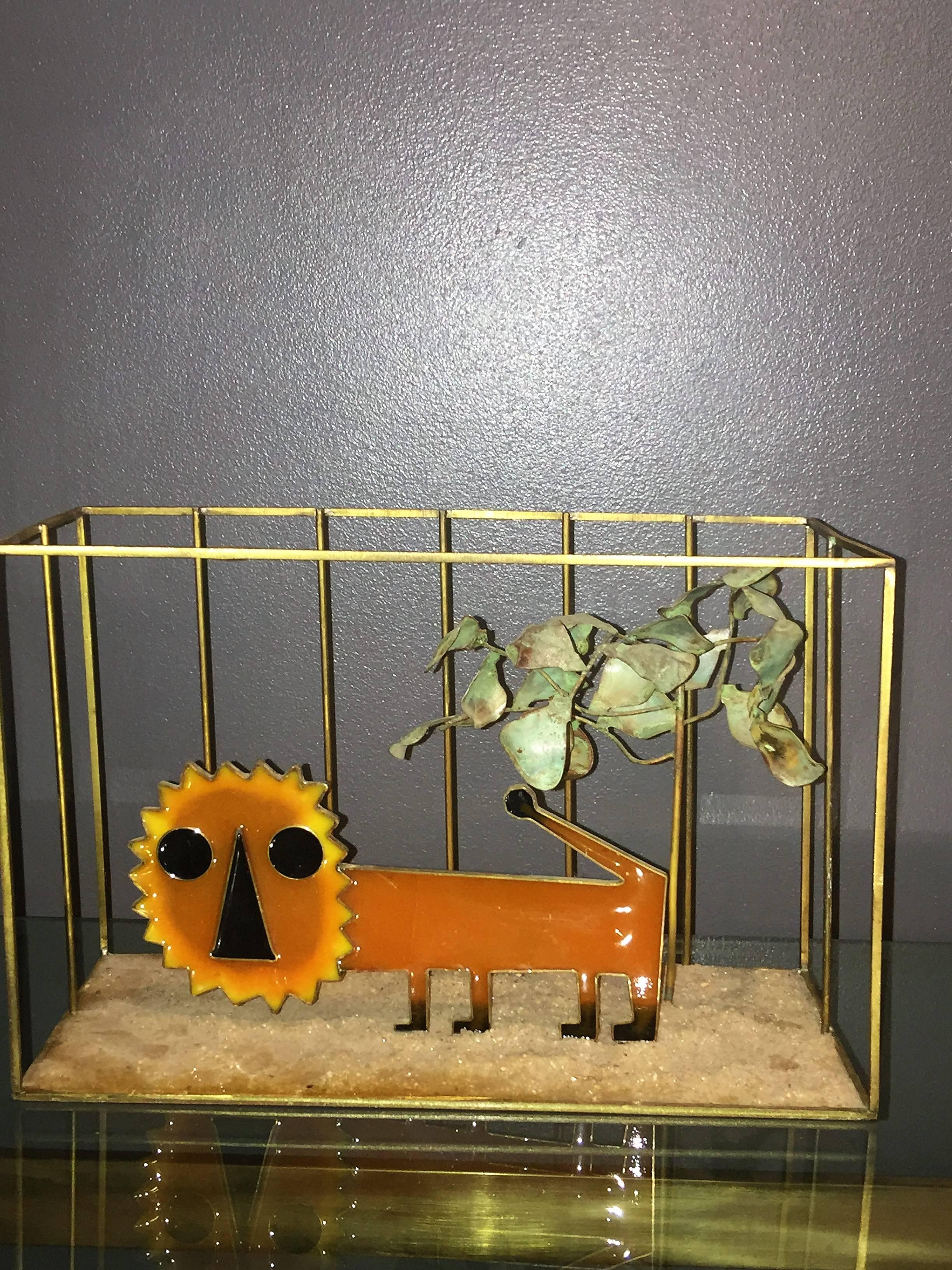 Adorable pop orange resin lion in brass cage with brutalist form patinated tree on sandstone decorated base. The lion is framed in brass with black in brass frame nose and eyes. The paws are also black. Rare piece by Curtis Jere though unsigned.