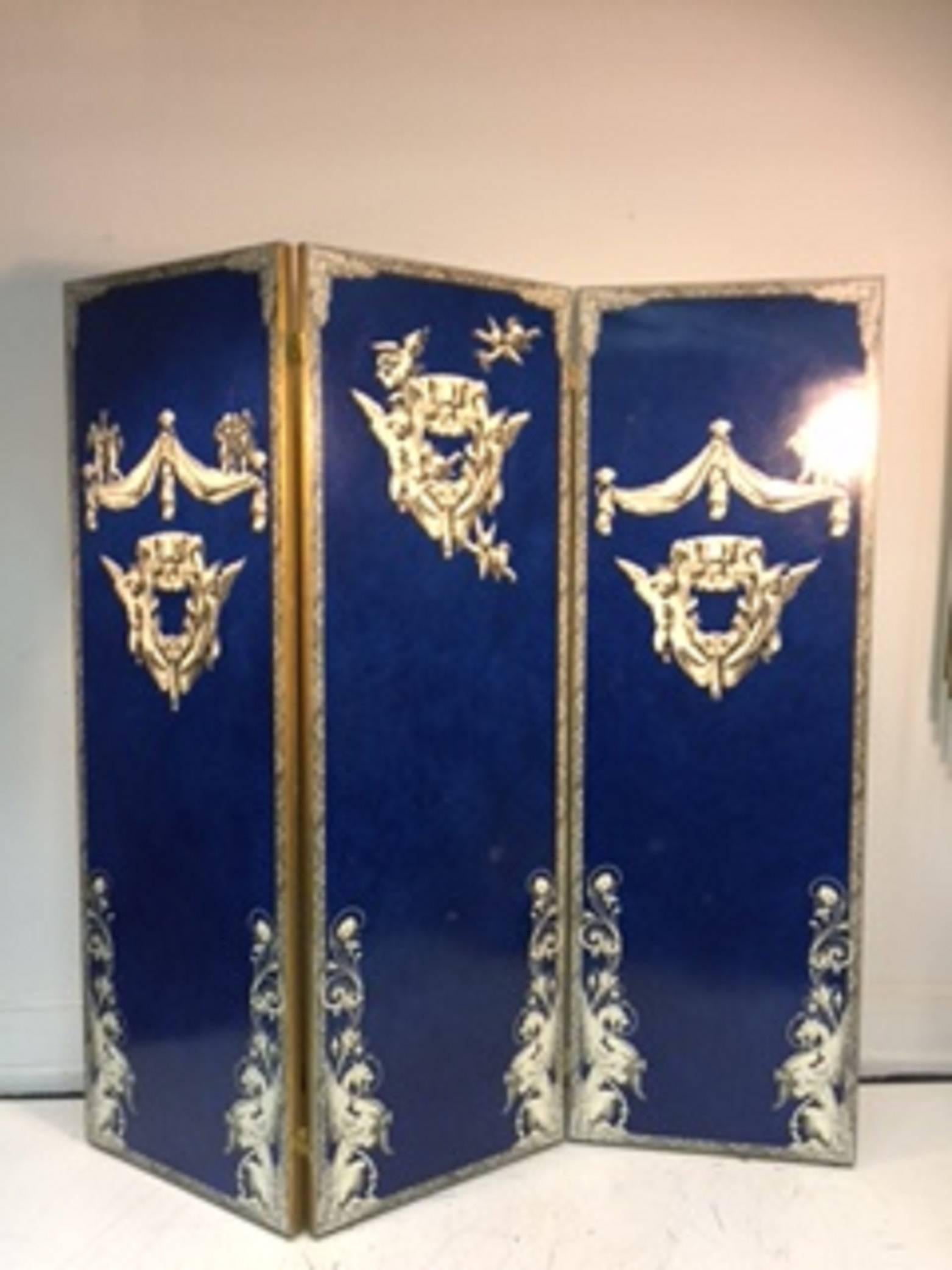 An exquisite cobalt blue three-panel decoupage screen with beautiful decoration in the manner of Piero Fornasetti, circa 1960.