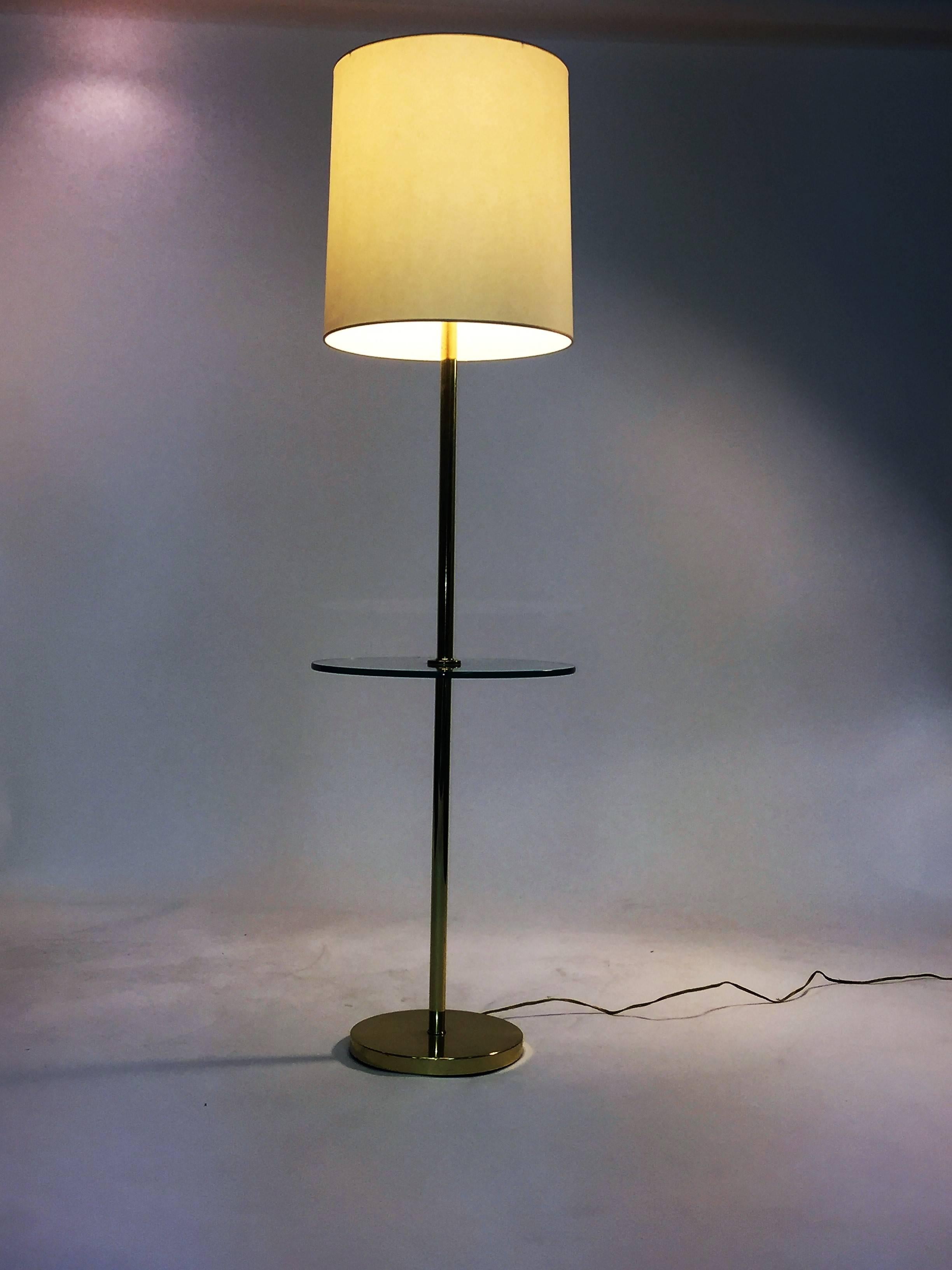 1970s round glass attached table brass floor lamp with brass ball design finial. Taking one standard bulb with the switch on the top. The round brass base measures at 10
