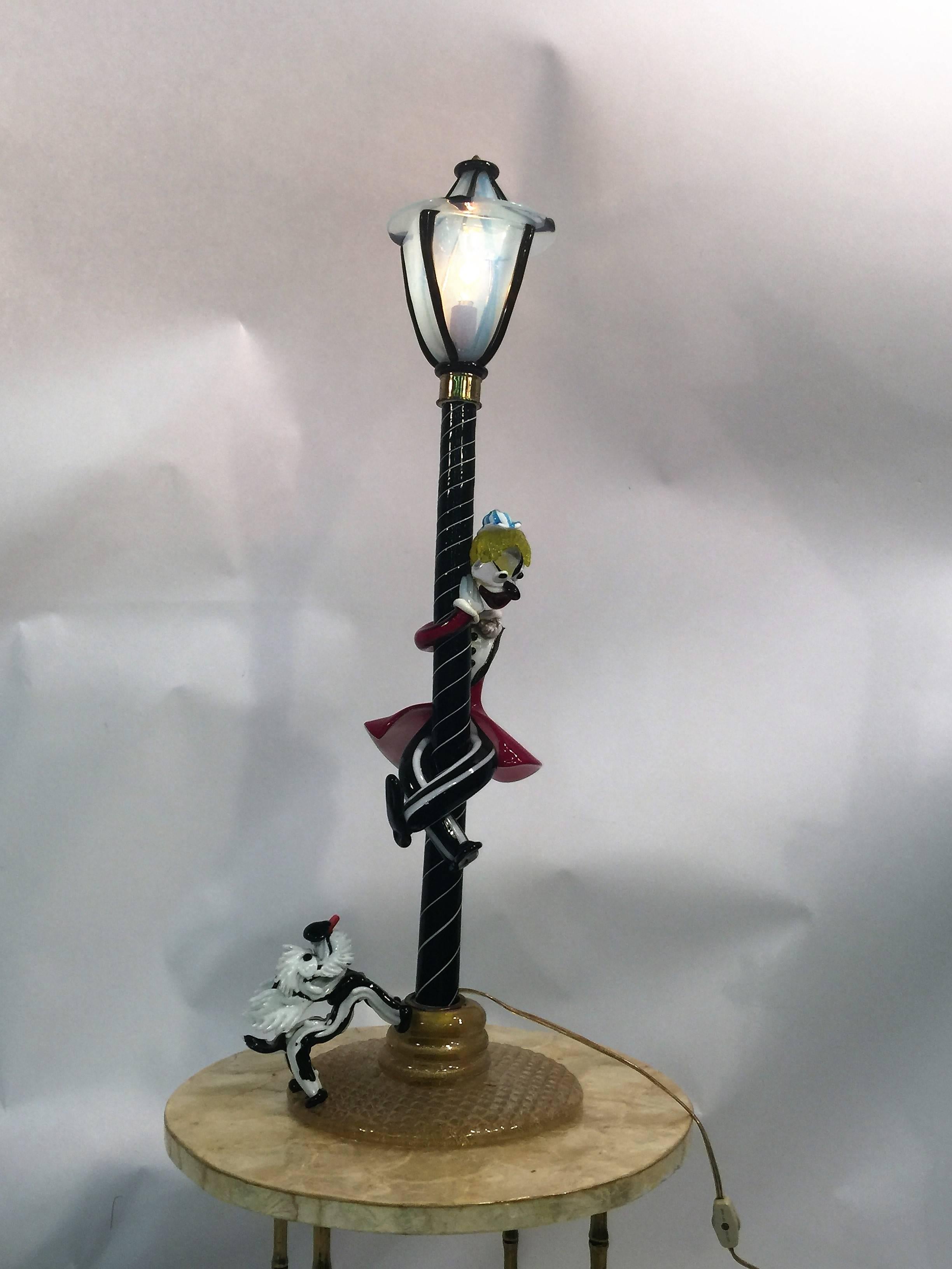 Created by Gino Cenedese in the 1950s this is an amazing handblown clown climbing up a street lamp with a angel dog at his heels. Many masterful glass techniques were used in creating this magical piece. The lamp post is swirled black and white