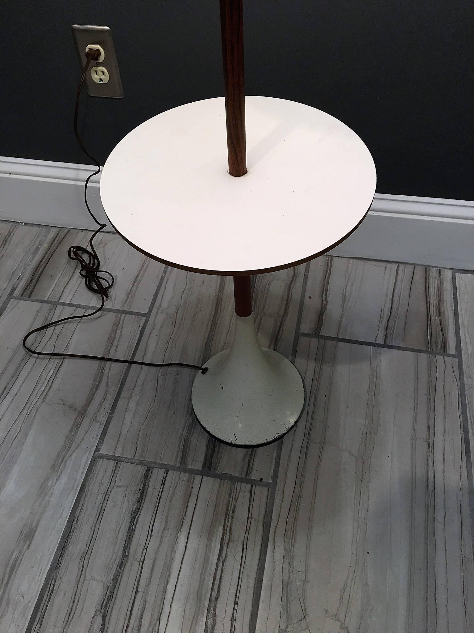 Modern design floor lamp with white laminate round table in centre and white enameled metal sculptural base. Teak lower stem and rosewood laminate upper stem. The diameter of the round table is 11 1/2