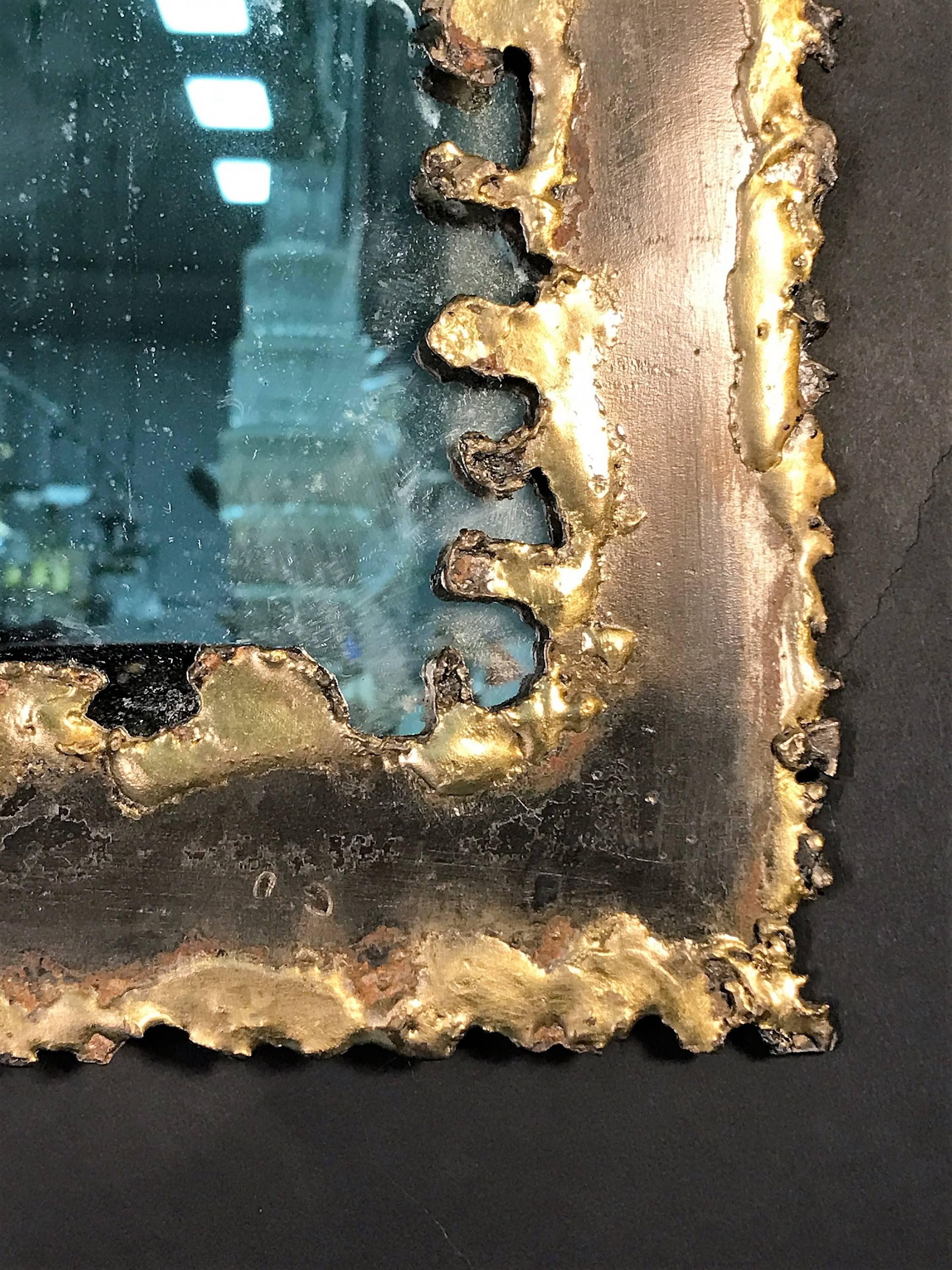 Great bronze and gold flared torch cut metal mirror.