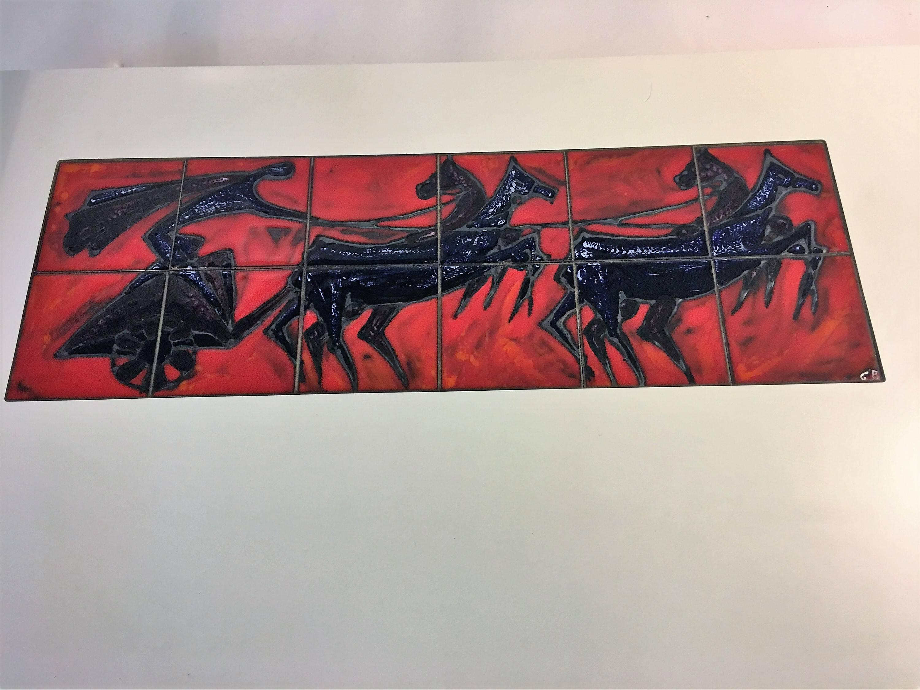 Gorgeous zig zag chrome frame coffee table with inset handmade vibrant red tile scene of modernist horse drawn chariot. The lower tier is a white laminate with rosewood trim sides. The thick glass rectangular top rests in the top frame. Measures:
