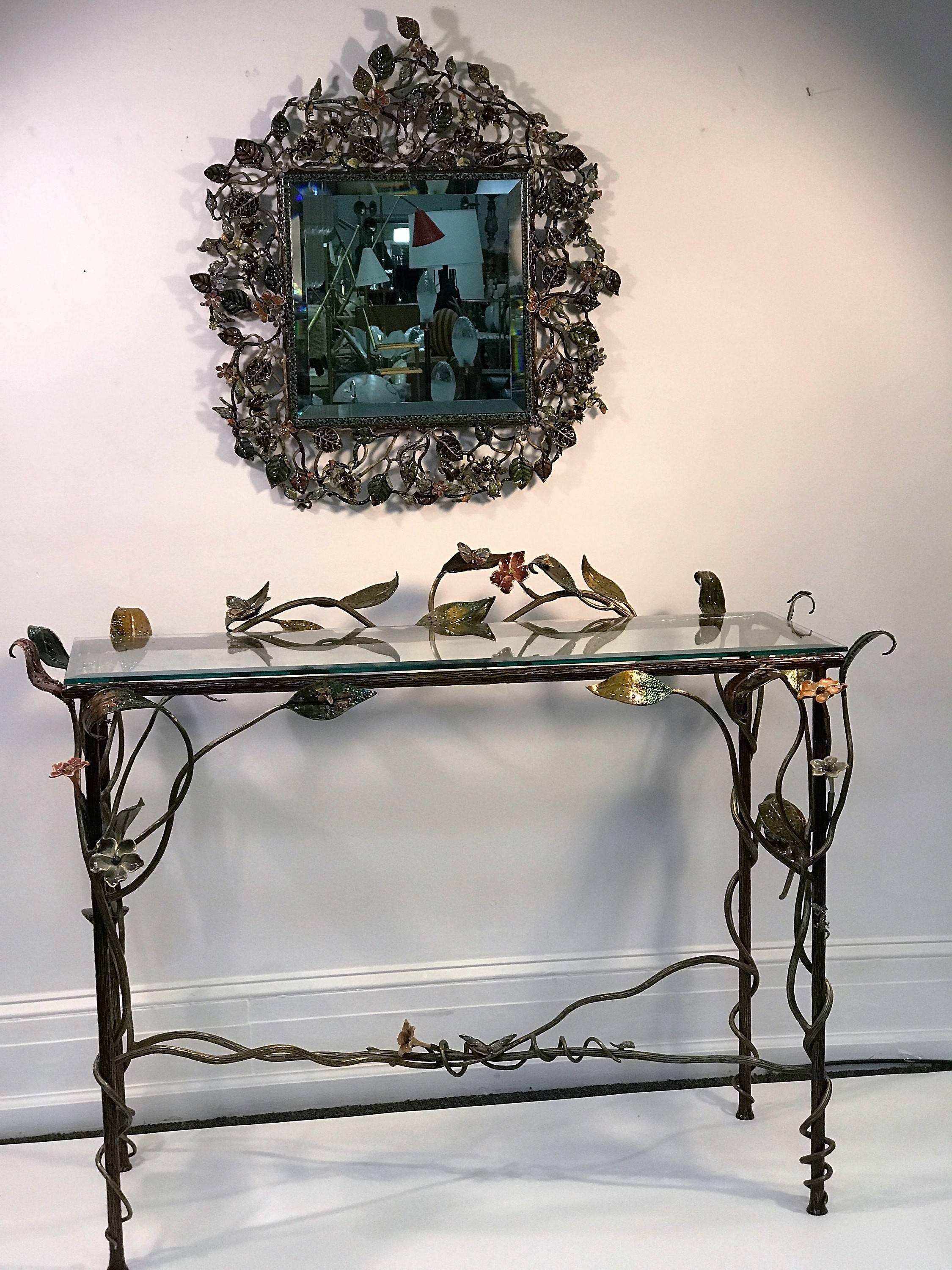 Beautiful and intricate multicolored poly chromed enamel on bronze jewel encrusted console teamed with matching wall mirror. Decorated with morning glories, wild flowers, butterflies, lizards, bees, salamanders, frogs, dragonflies and a snail. This