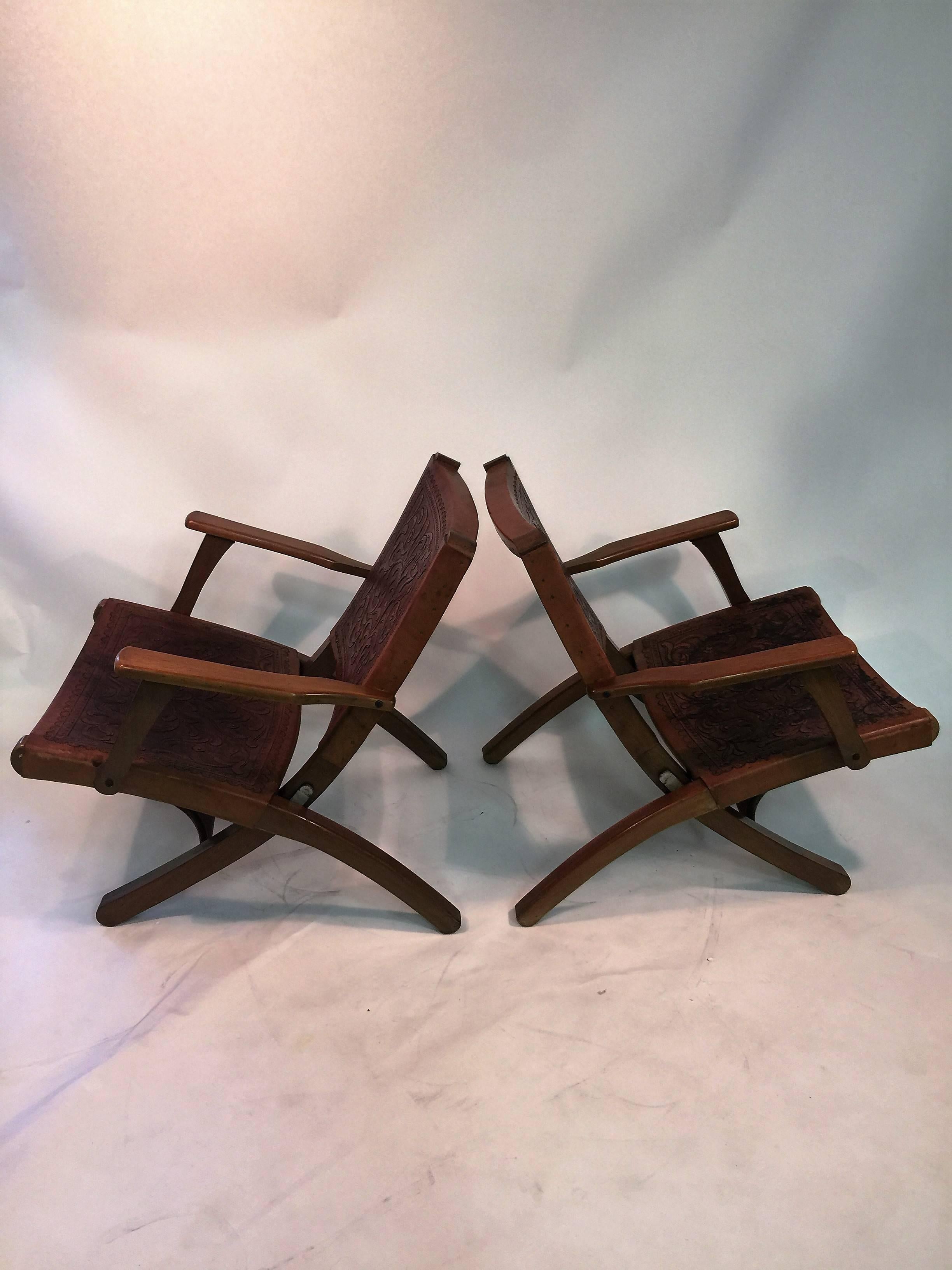 Wonderful Mid-Century sculpted wooden chairs with beautiful hand tooled saddle style leather seats and backs in a stylized vine design. In original vintage condition there is some wear and dark spots to the hand tanned and tooled leather, otherwise