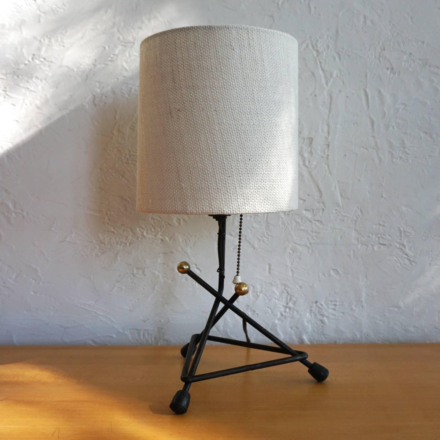 1950s iron table lamp with brass elements. Original finish to the lamp, with a new shade.

Measurements include the shade.