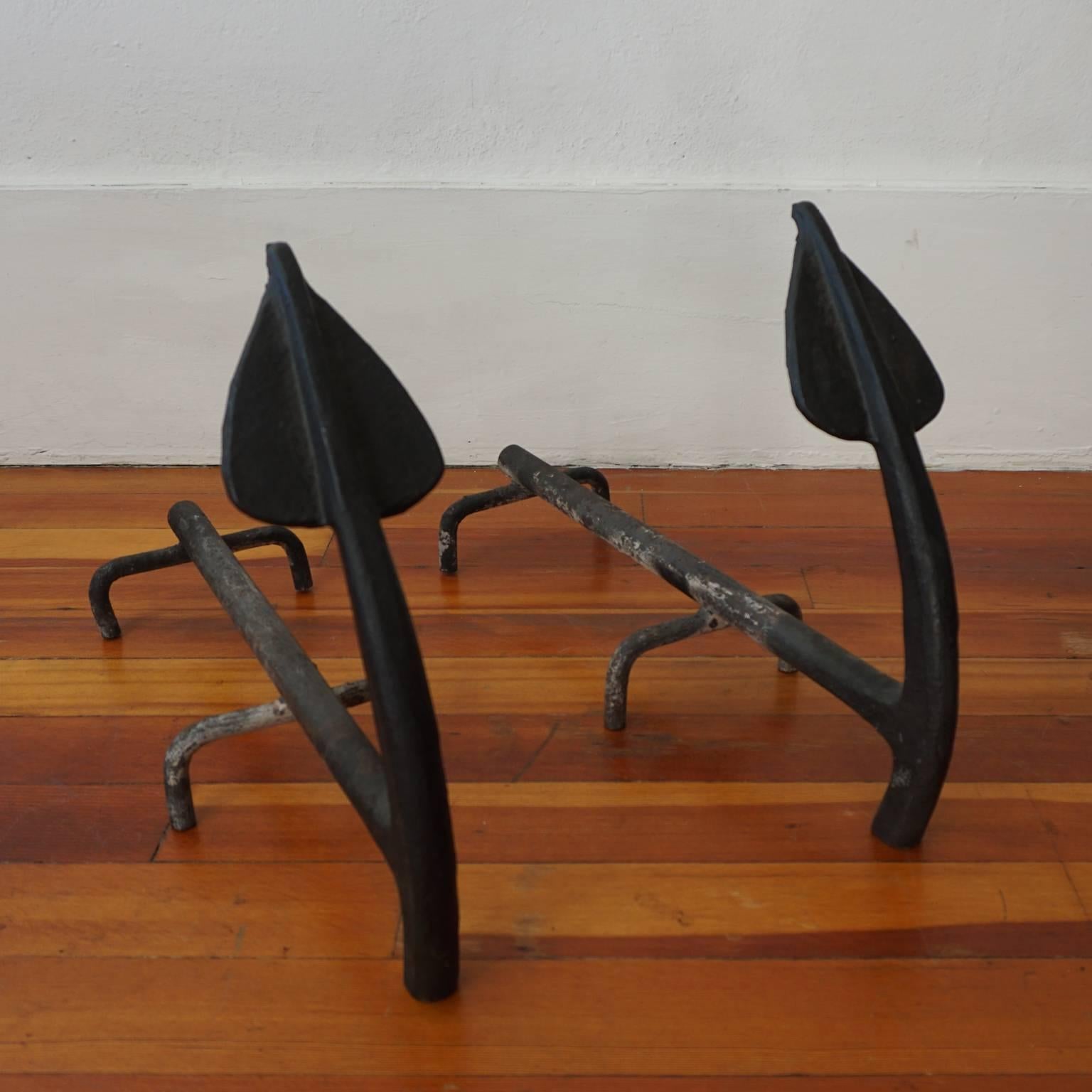 A pair of solid iron andirons from the 1940s.