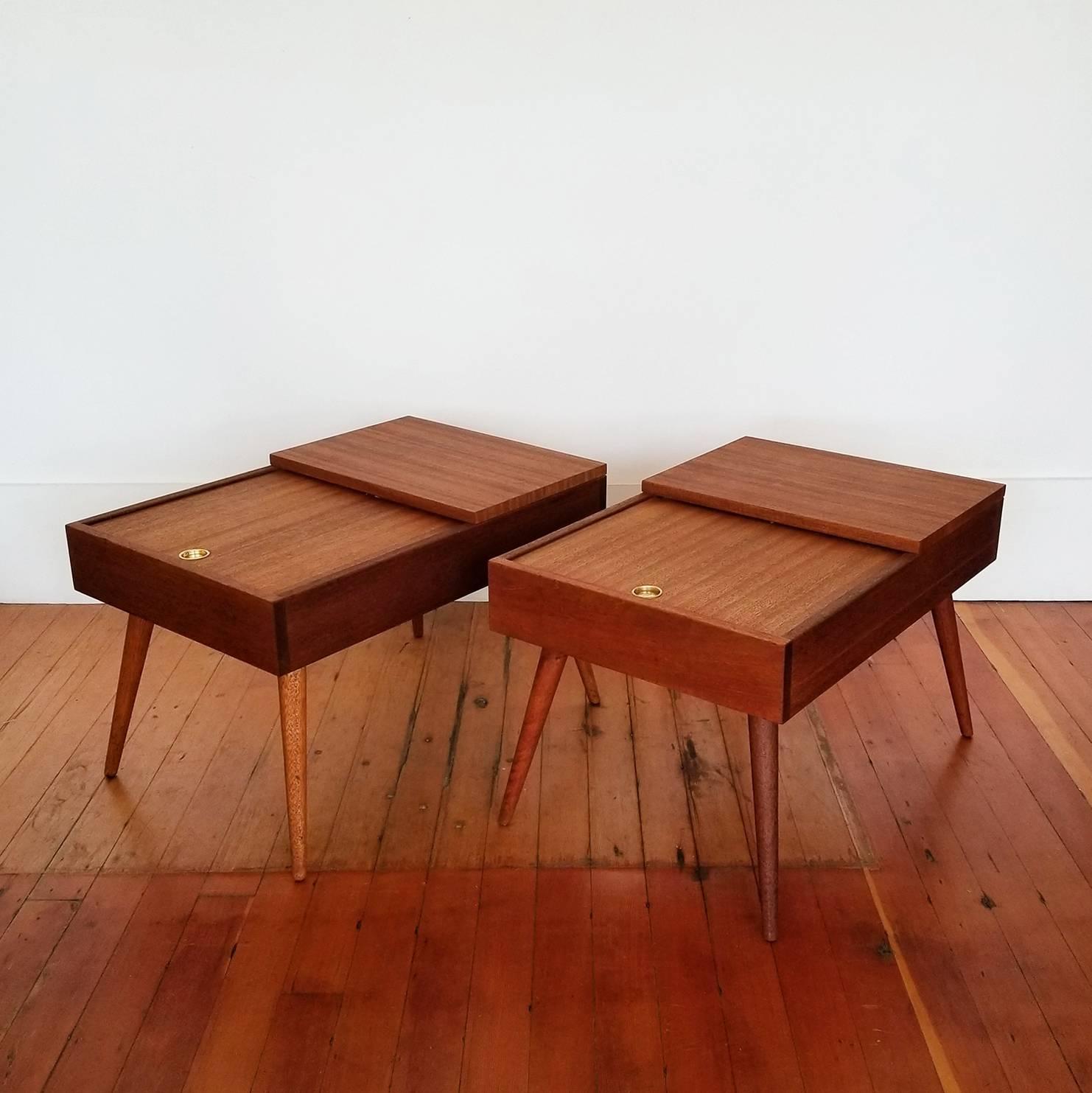 A pair of end tables with sliding door access to storage. Shimmering solid Philippine mahogany construction. Designed by California Designer, John Keal. Signed with a 1950s Brown Saltman logo.