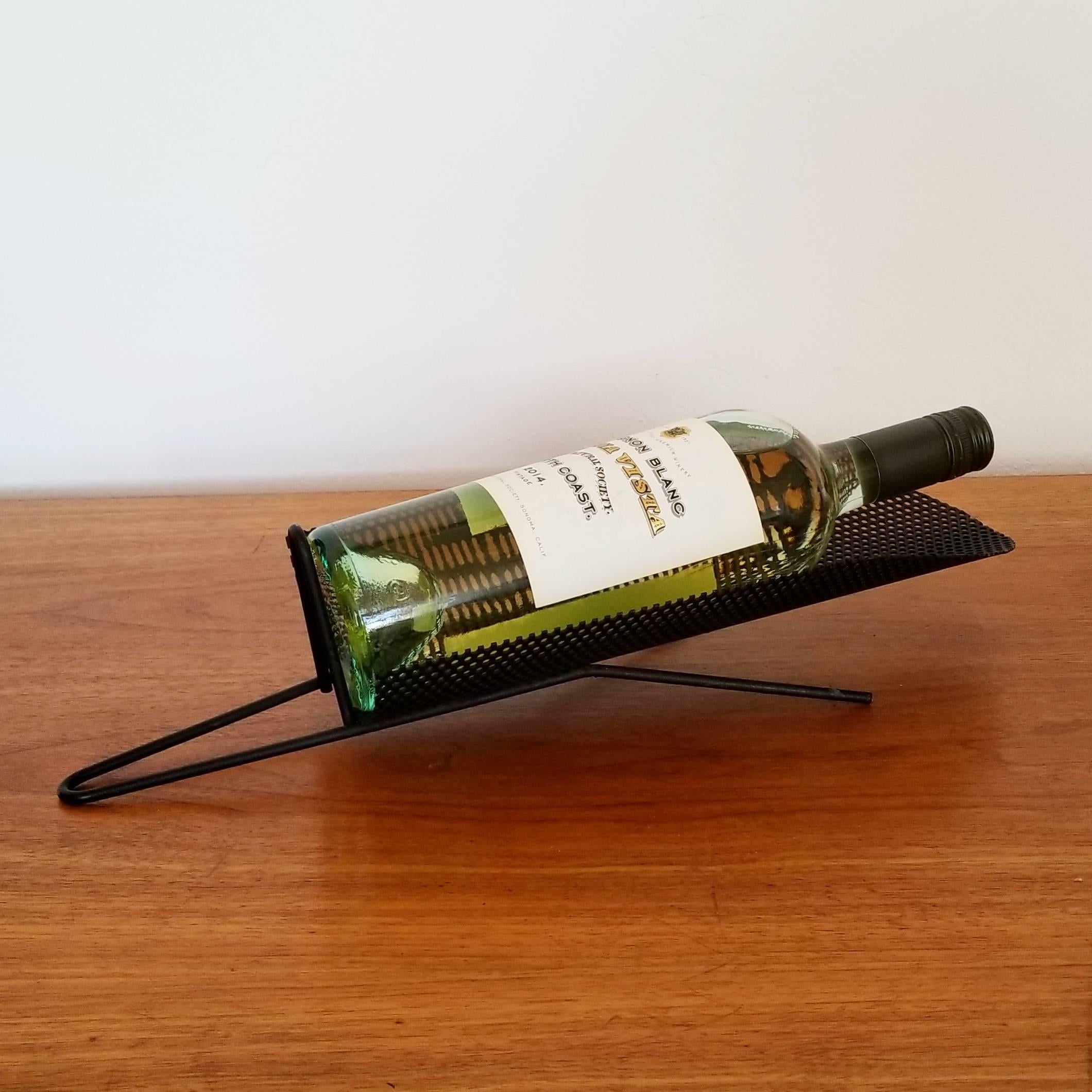 Early 1950s wine bottle holder constructed of perforated metal with hairpin elements.