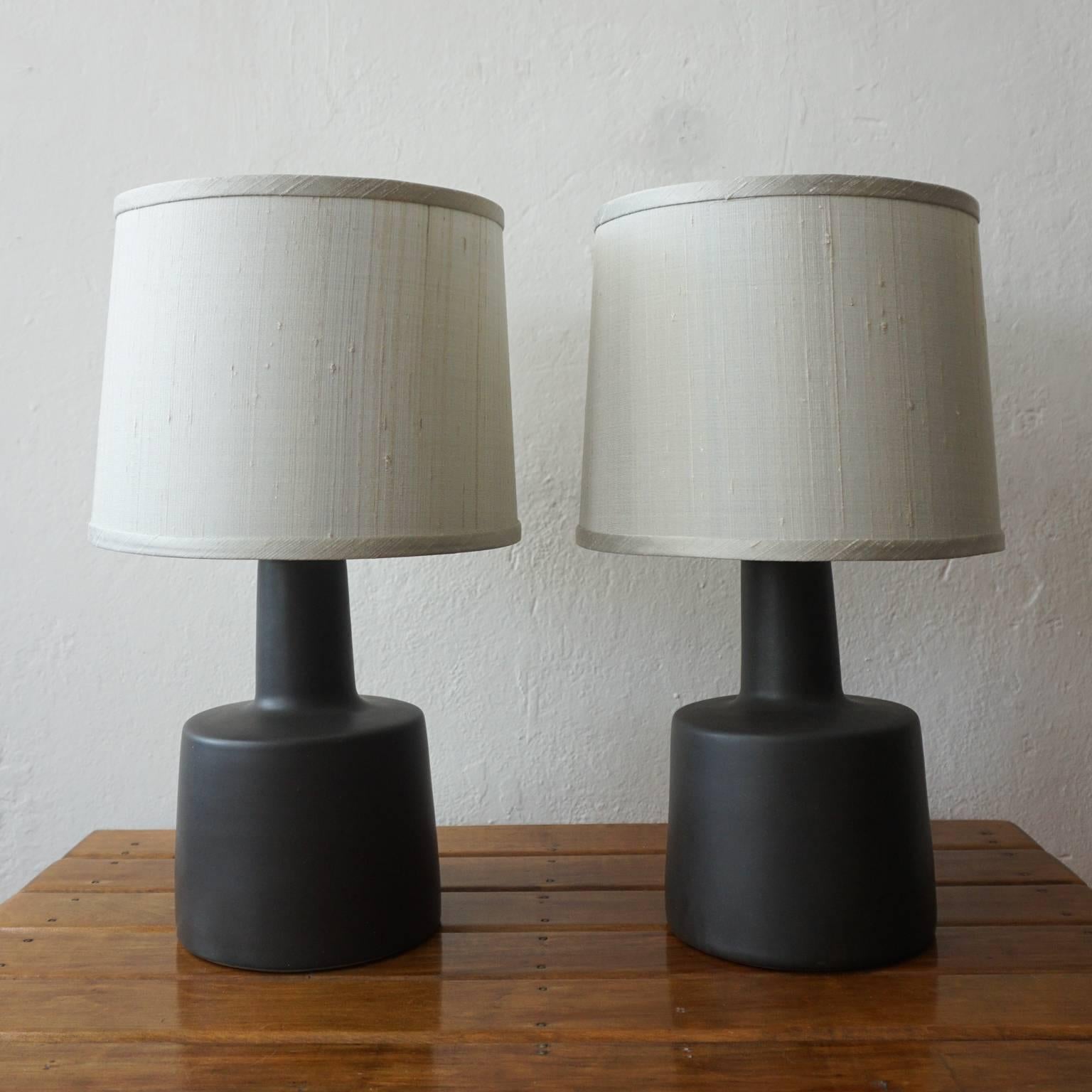 Pair of ceramic table lamps by Jane and Gordon Martz for their company, Marshall Studios. Charcoal base with new light gray shades. Signed in the clay.