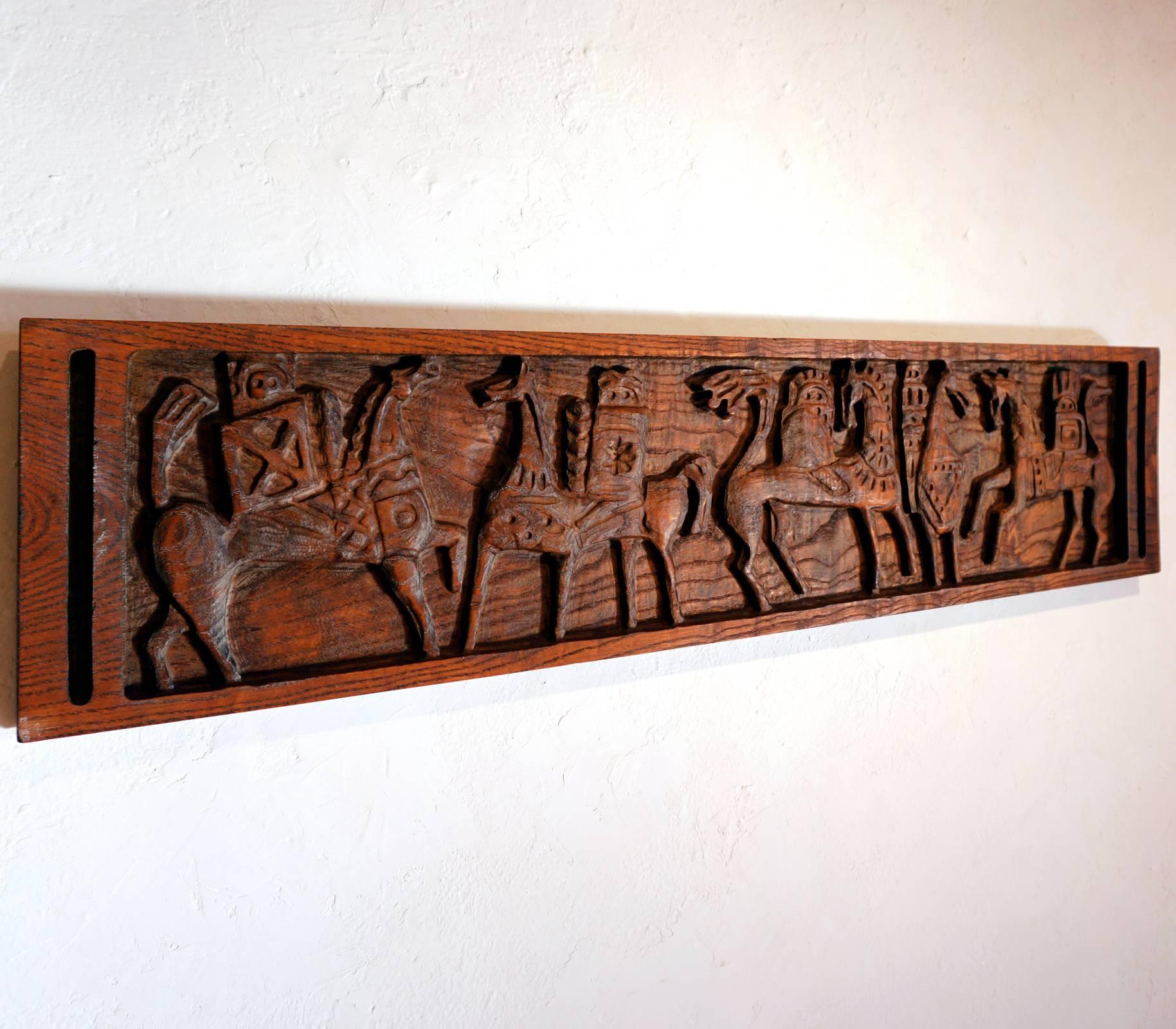 The Riders, 1963 carved wood wall panel by Evelyn and Jerome Ackerman. Signed on the back. There are two hanging brackets mounted to the back.