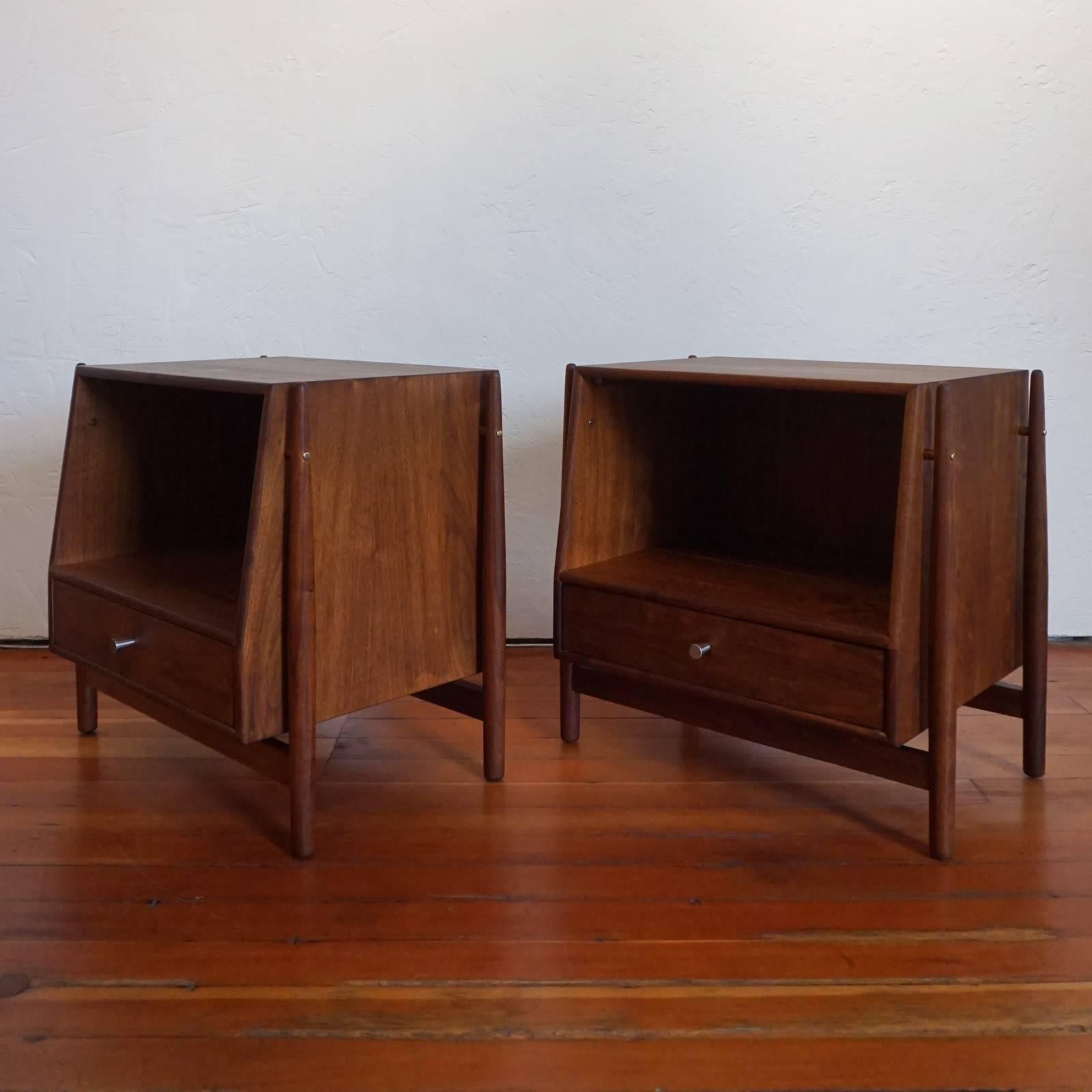 A pair of walnut nightstands by Kipp Stewart and Stewart MacDougall for Drexel. Floating cabinets with brass accents. Each drawer has a removable interior divider. Refinished.