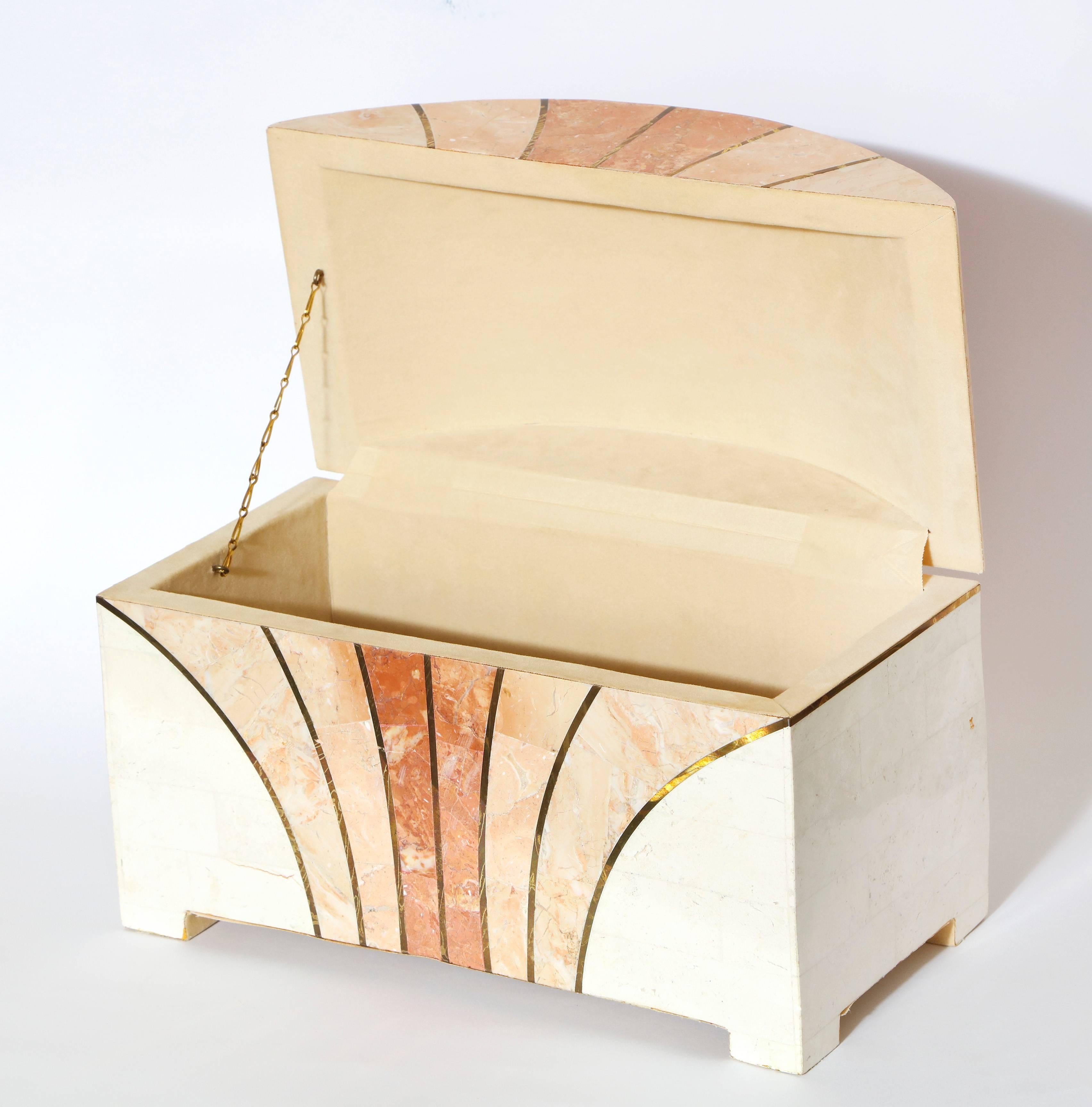 A Maitland-Smith vintage 1970s arch shaped tessellated stone box with decorative brass inlay; the stone in beautiful shades of rich corals and cream. The interior lined in cream velvet with brass chain link support. In excellent condition.