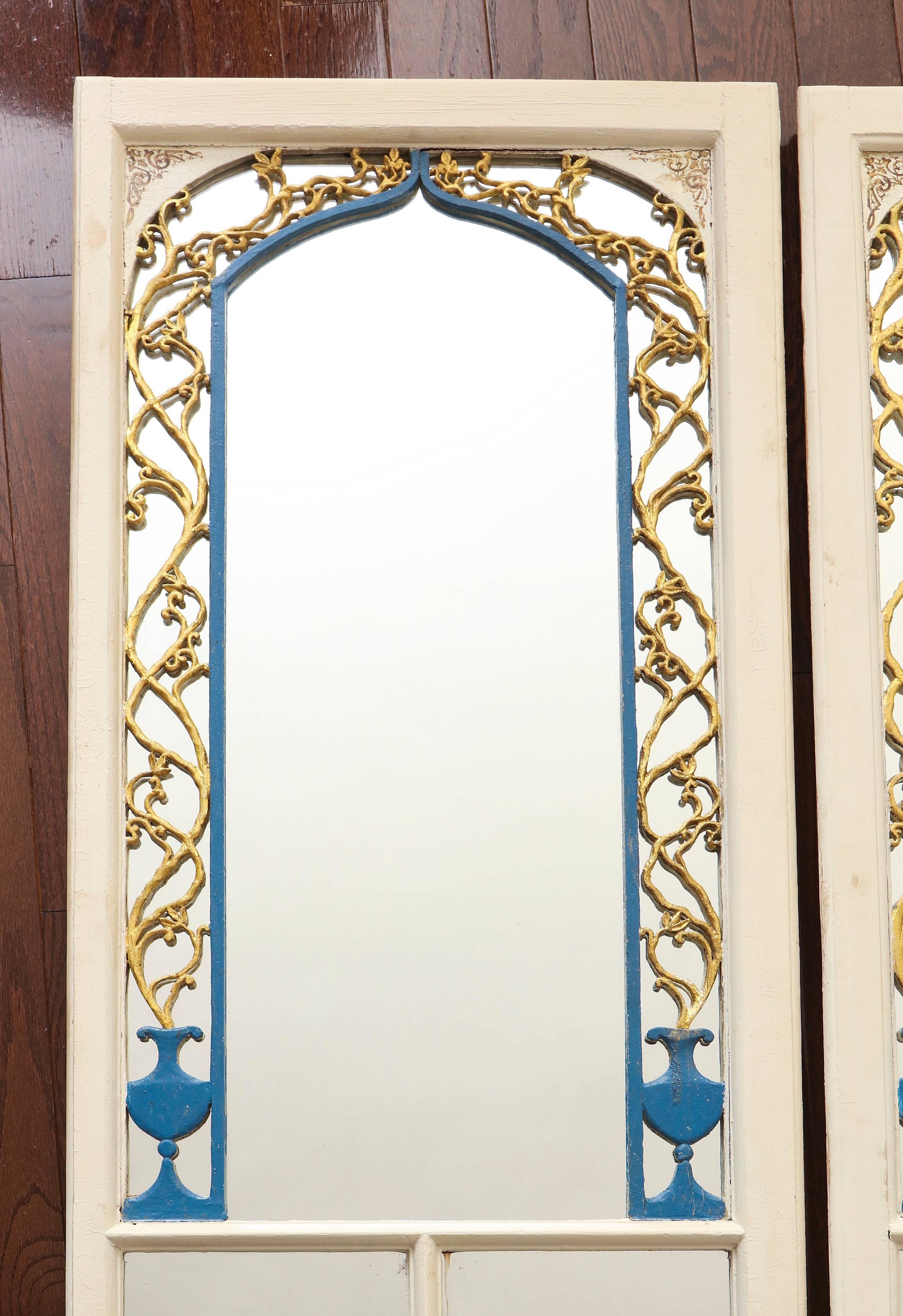 A pair of carved, gilt and painted blue and white Portuguese wood cabinet doors mounted as pier mirrors, circa 1800, with carved arch, cups and coral ornamentation.
 