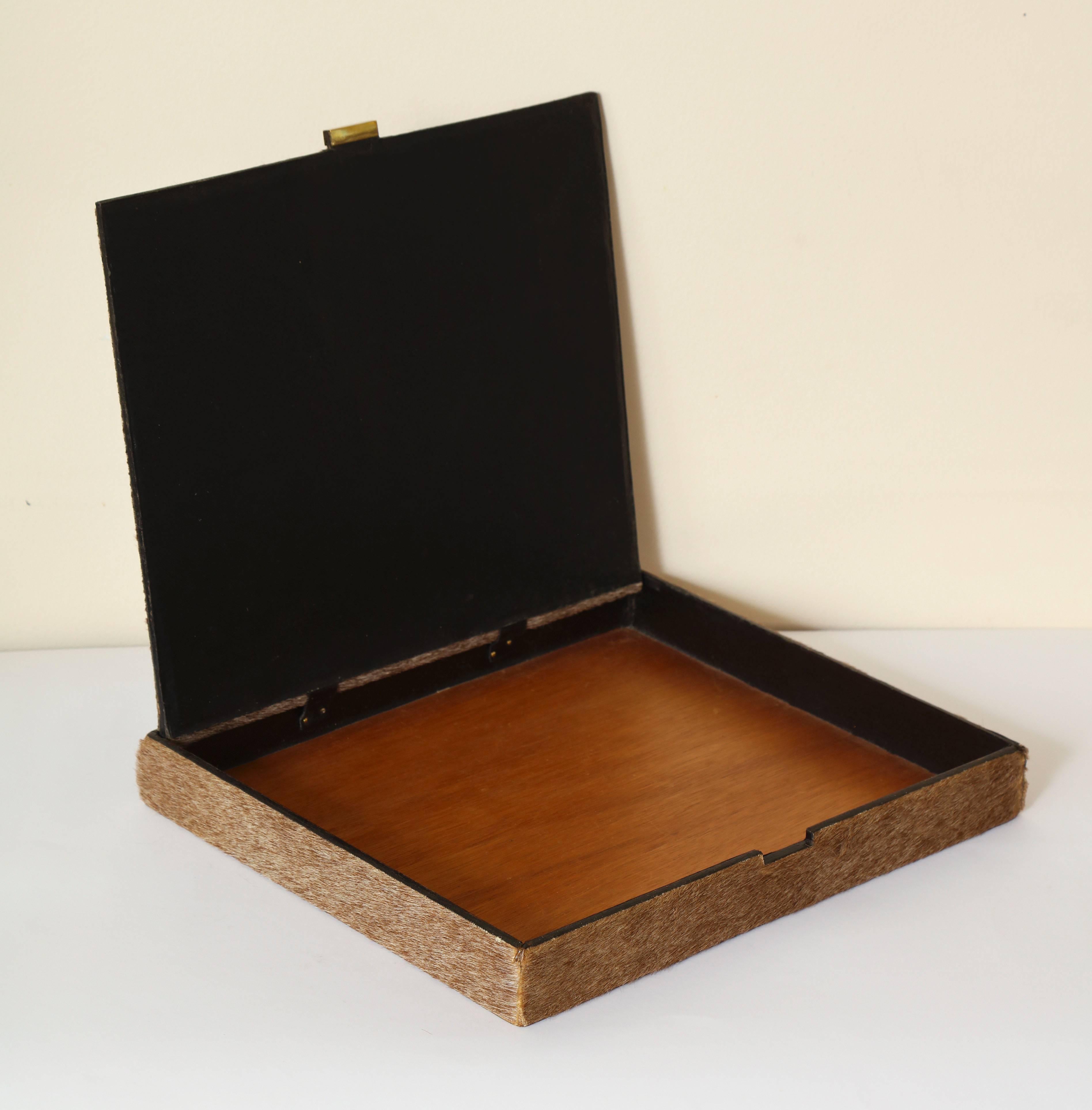 A fur lined and brass wooden box in the style of Meret Oppenheim.

      