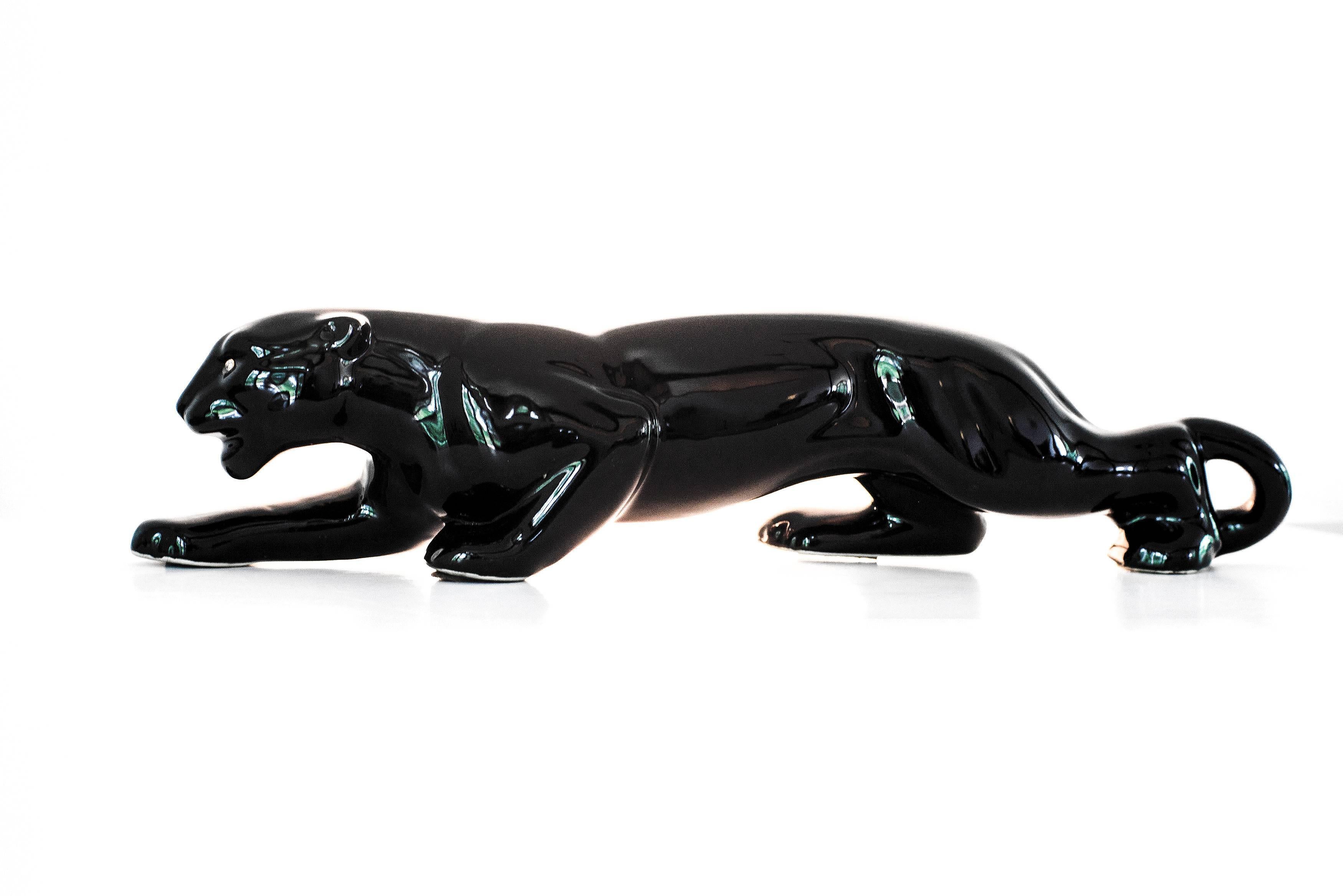 A vintage Mid-Century Modern ceramic Black Panther television figurine lamp, with rhinestone eyes. These figurine T.V. lamps were manufactured in the 1950s when American households were buying and watching T.V. en masse; the back-light of the
