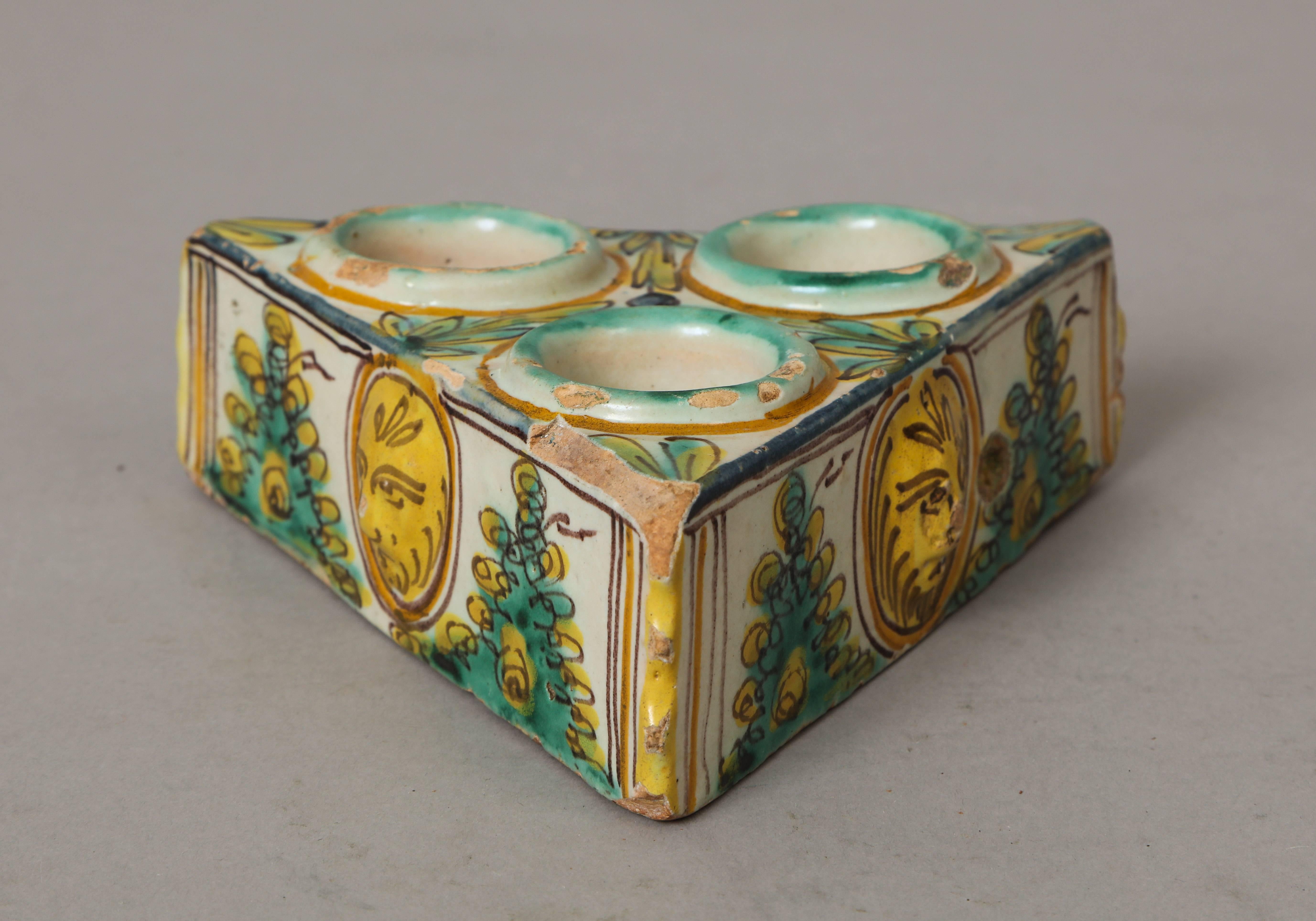 A charming Spanish late 17th century ceramic polychrome salt cellar in turquoise, cream and yellow; with masquerone and foliage motif; with three bowls.
Size: 2” high x 6”.