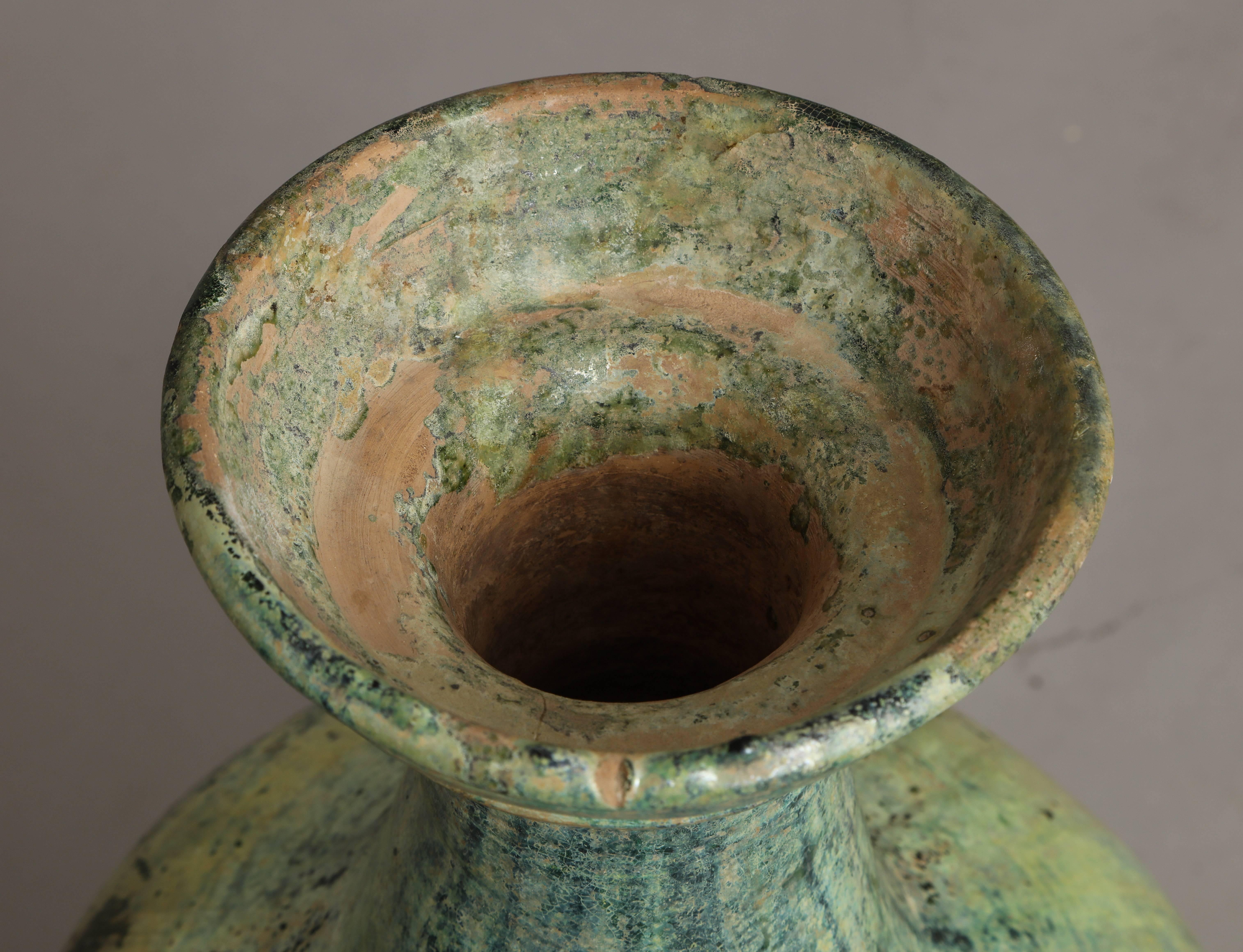 A Han Dynasty ceramic vase or jar with silvered green glaze and dish-shaped mouth, with dramatic silvered, blue and green iridescence. These ceramic pieces were made to resemble ancient bronze vessels. They were used in many tomb burial sites, the