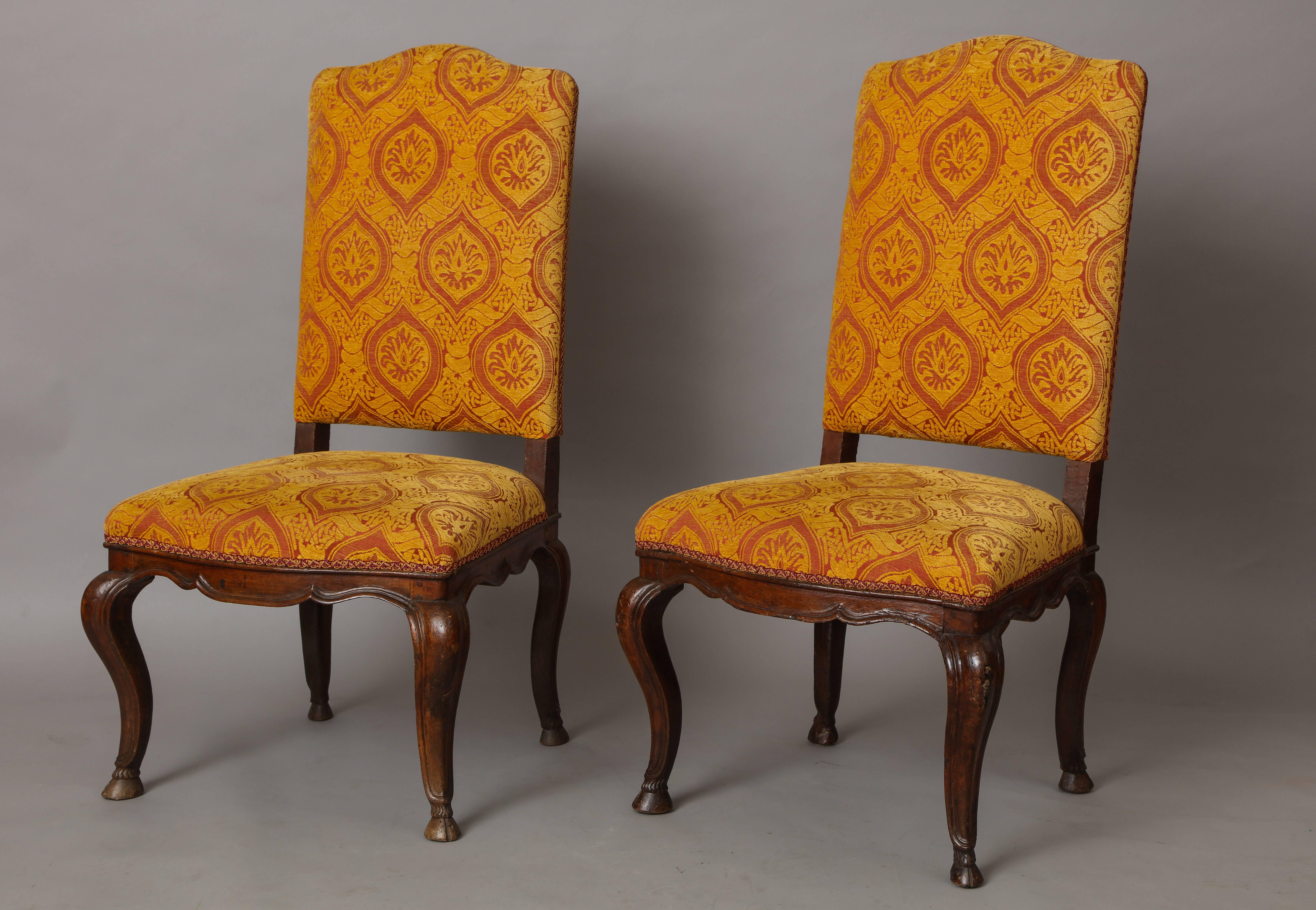 A pair of Italian exuberantly carved walnut side chairs with dramatic cabriole legs and carved aprons, upholstered in a sumptuous patterned velvet.
Milan, Italy, early 18th century.
   
