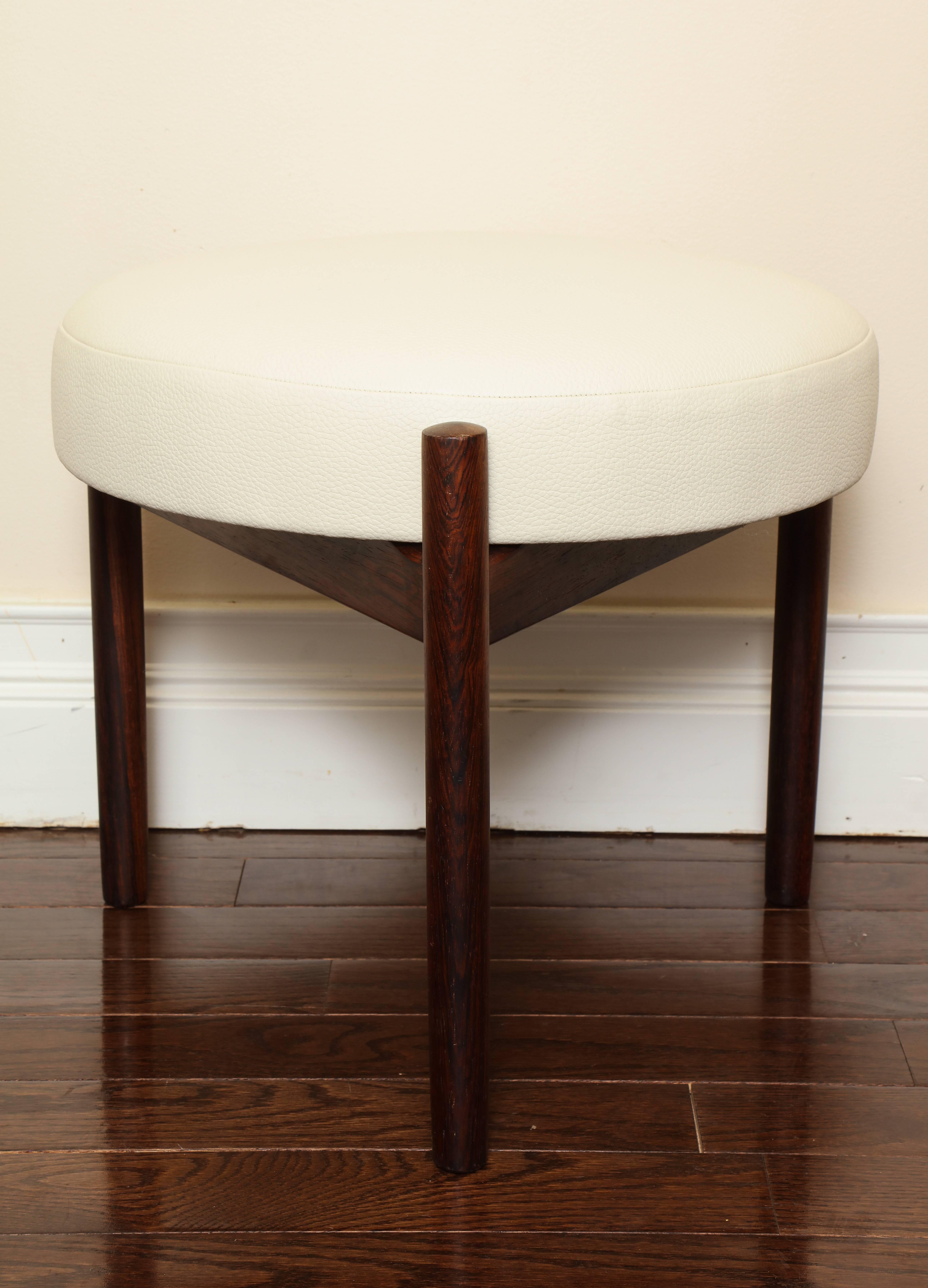 A Danish modern tripod triangular walnut stool with removable seat cushion; newly upholstered in creamy white pebble leather. 
Size: 16