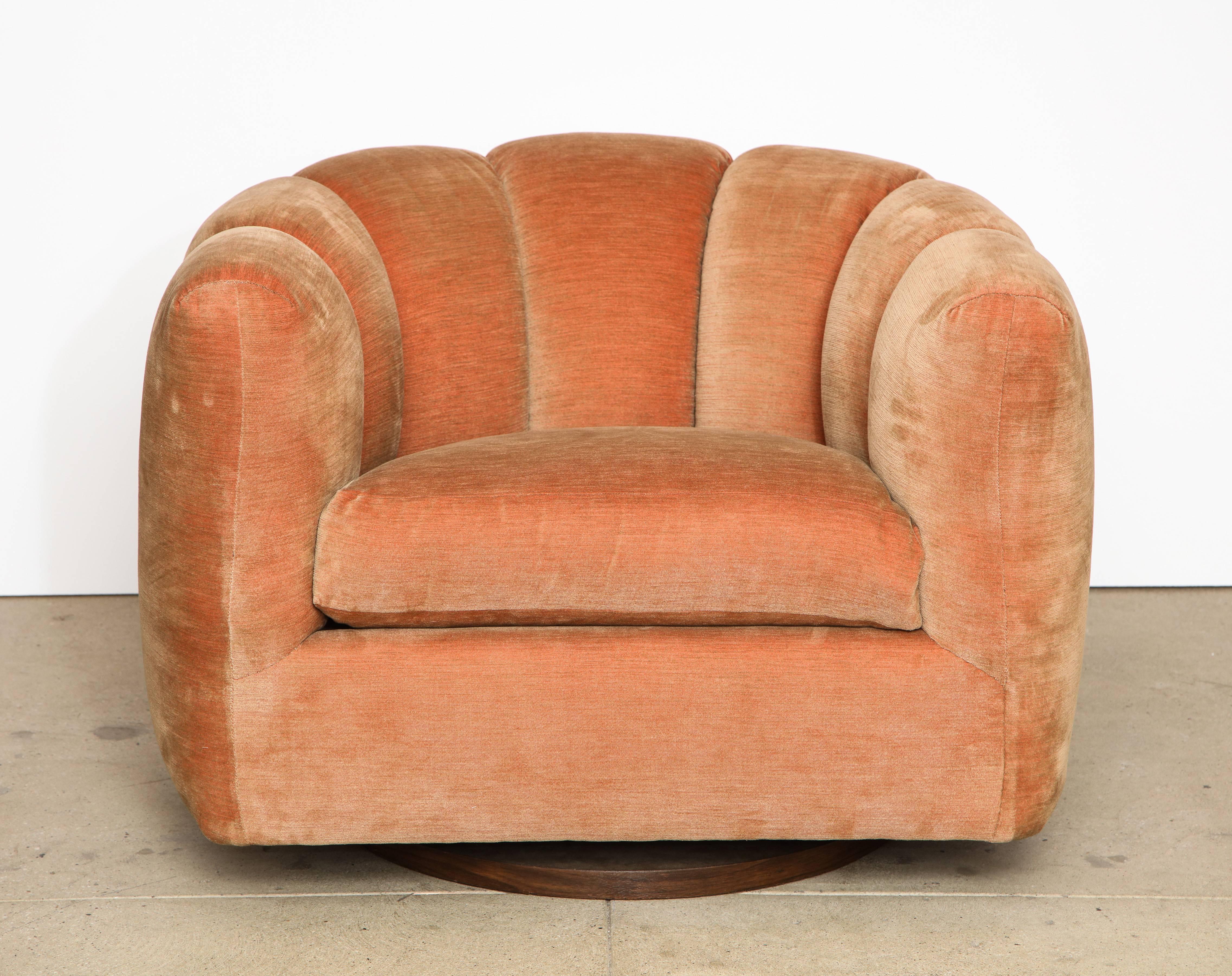 A pair of swivel armchairs with channel backs attributed to Milo Baughman, with their original peachy pink and brown velvet tufted upholstery; the tufting is finished all around. The upholstery is original and in excellent condition. Supported on a