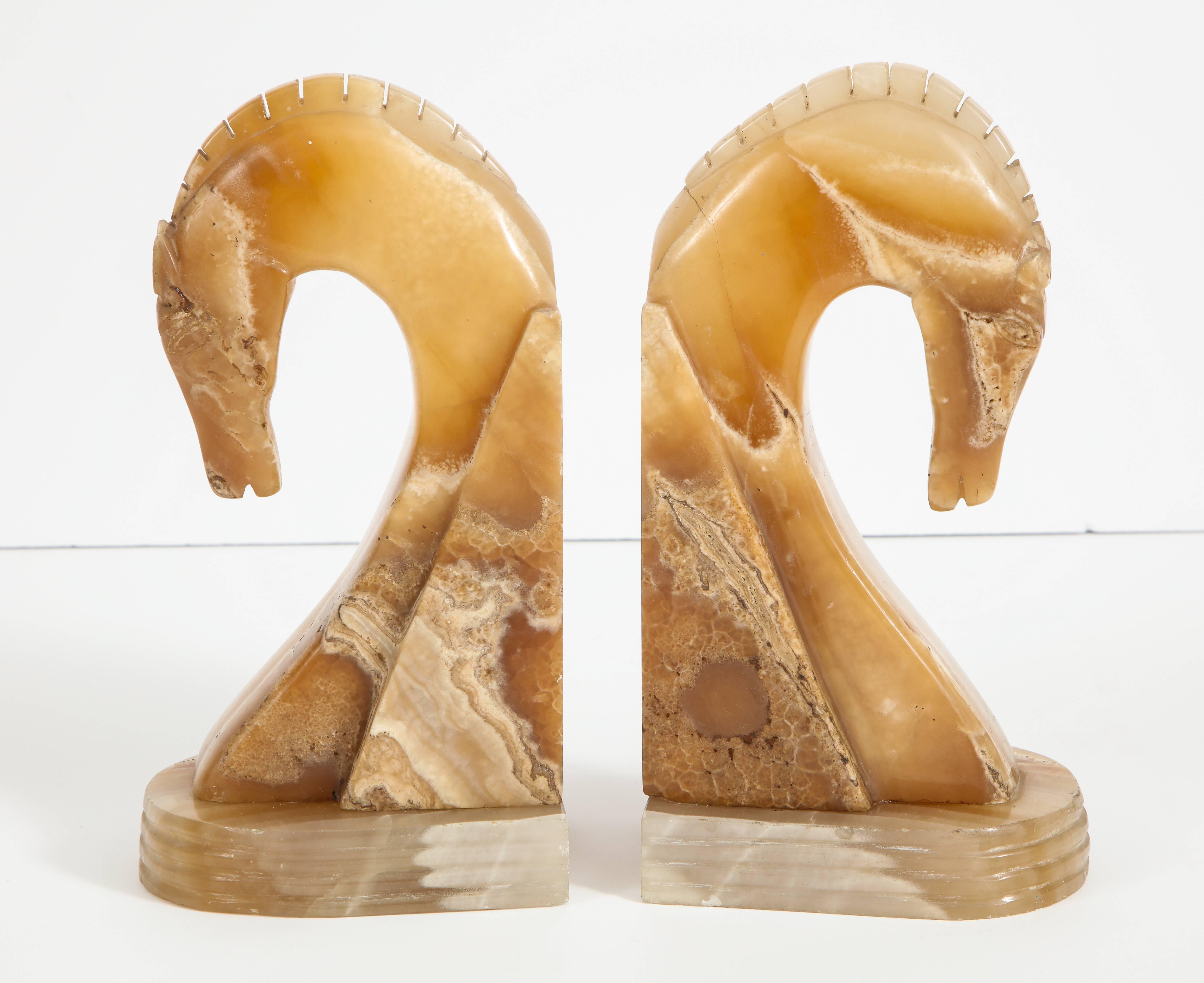 A beautiful and elegant pair of Art Deco hand-carved onyx horse head sculptural bookends with bowed head and ribbed bases.
Italy, circa 1940
Size: 11