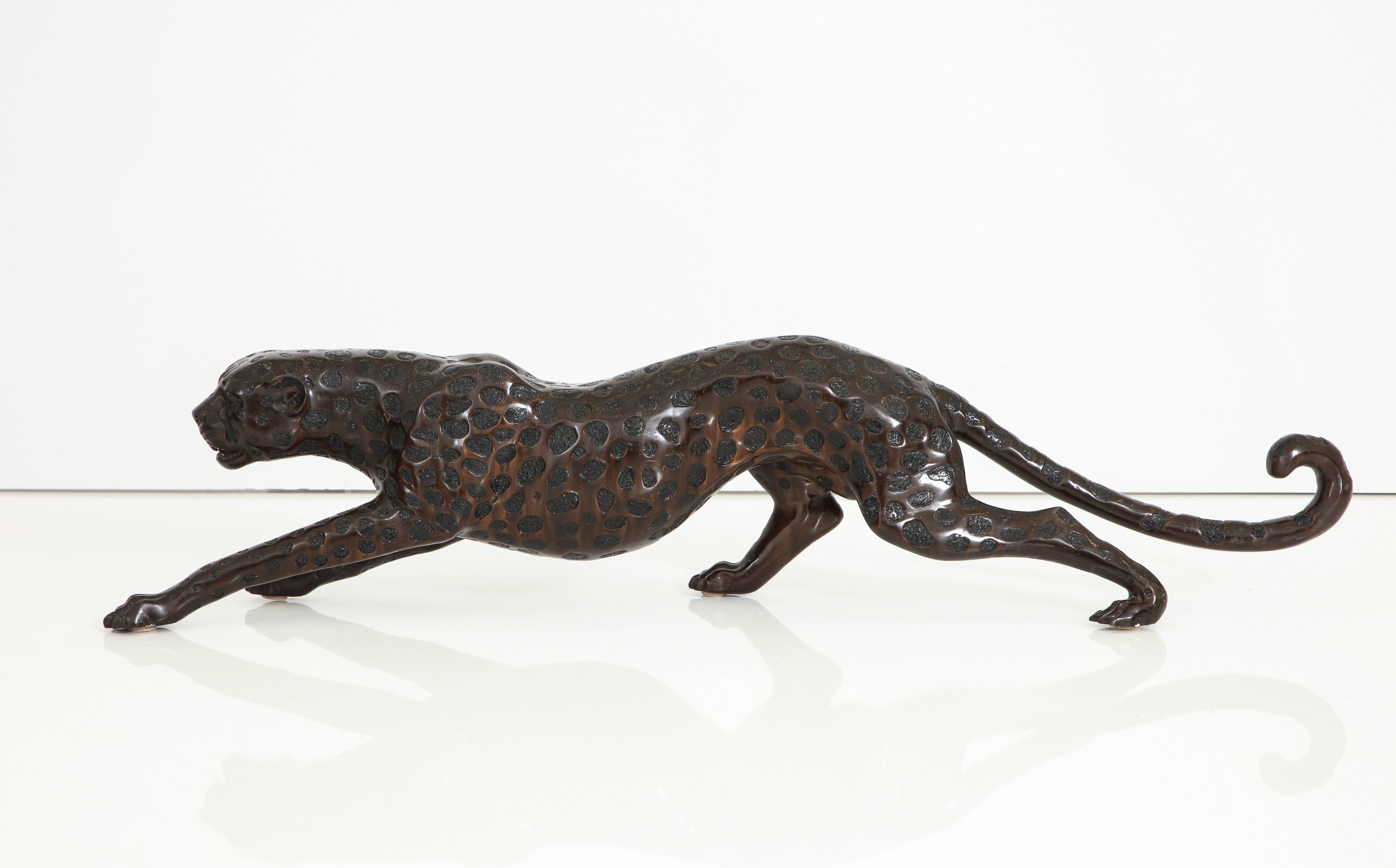 An Art Deco cast bronze sculpture of a Cheetah in Stride, painted and lacquered in brown/bronze with black painted spots. Dramatic and large in size; the body pose very dynamic and face very expressive, 
France, circa 1940 
Size: 11