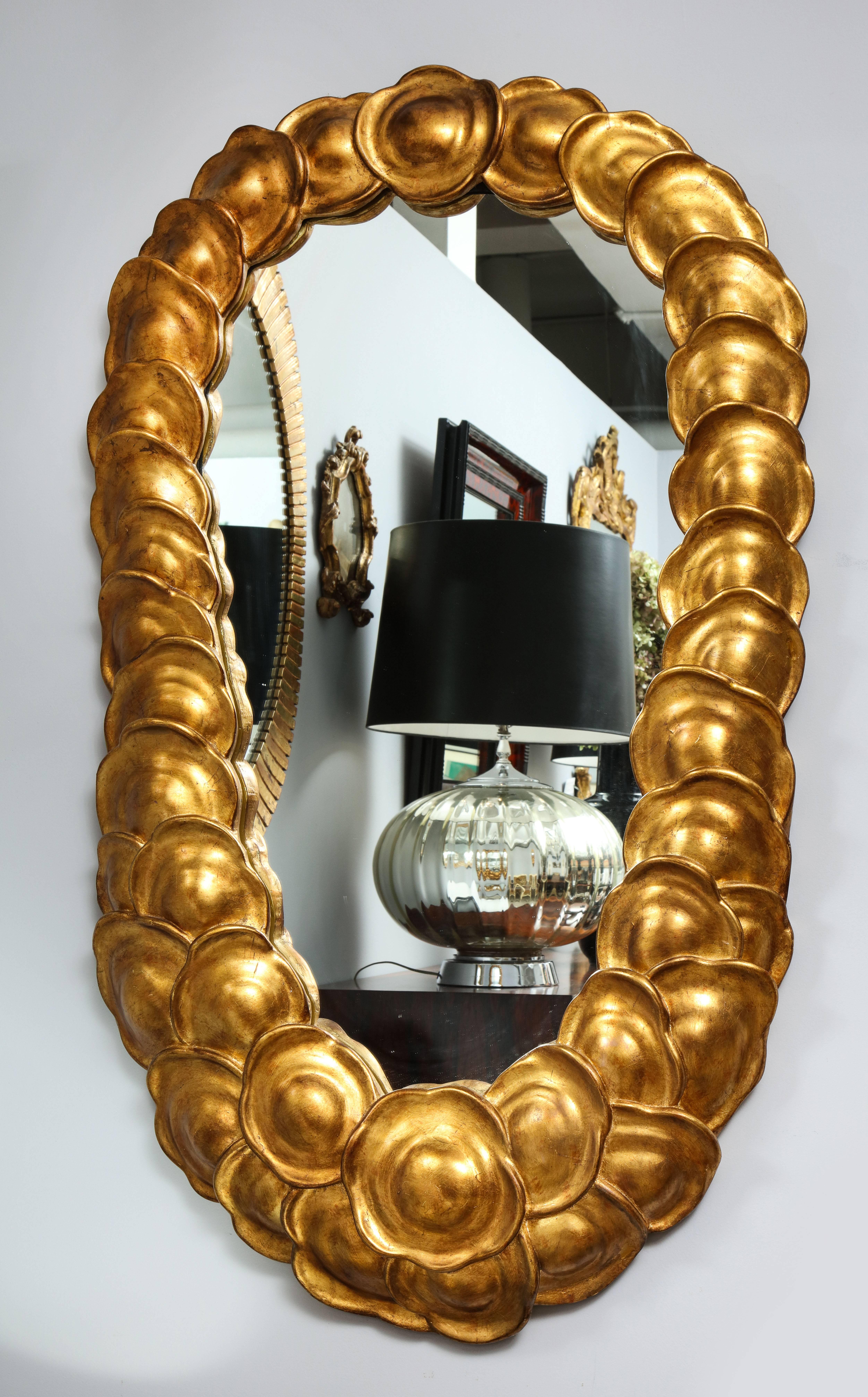 A very unusual, large and dramatic modernist gilded and carved mirror with overlapping carved disc design. 
Italy, circa 1960
Size: 51