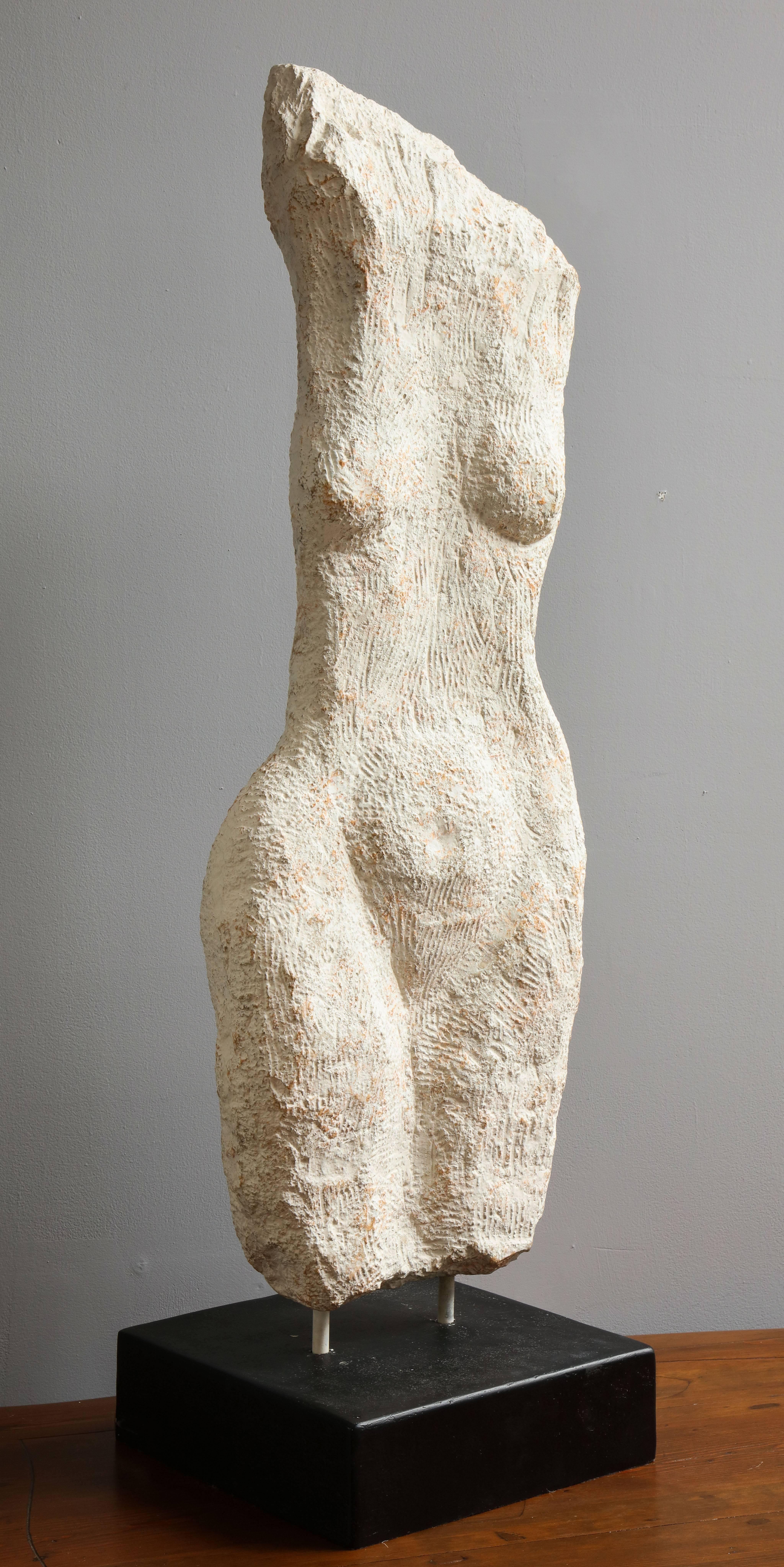 A modernist stone sculpture of a female nude torso, supported on a black painted stone plinth base.
American, 1970s
Size: 41 1/4