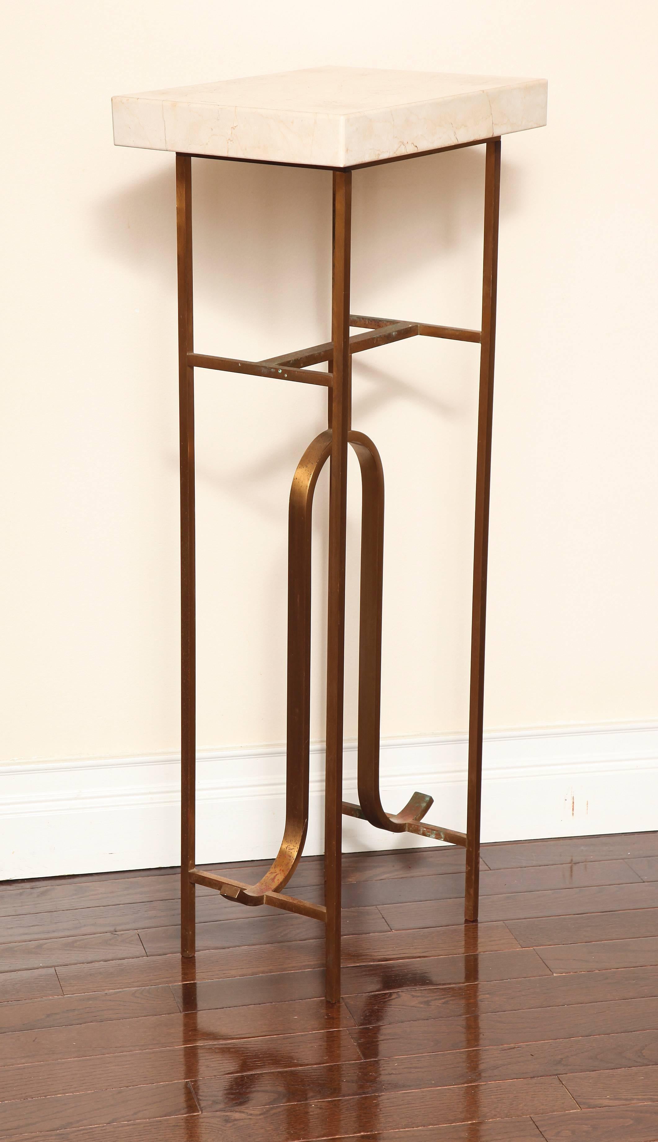 An Asian inspired bronze pedestal with a thick cream marble top; in the manner of Tony Duquette.