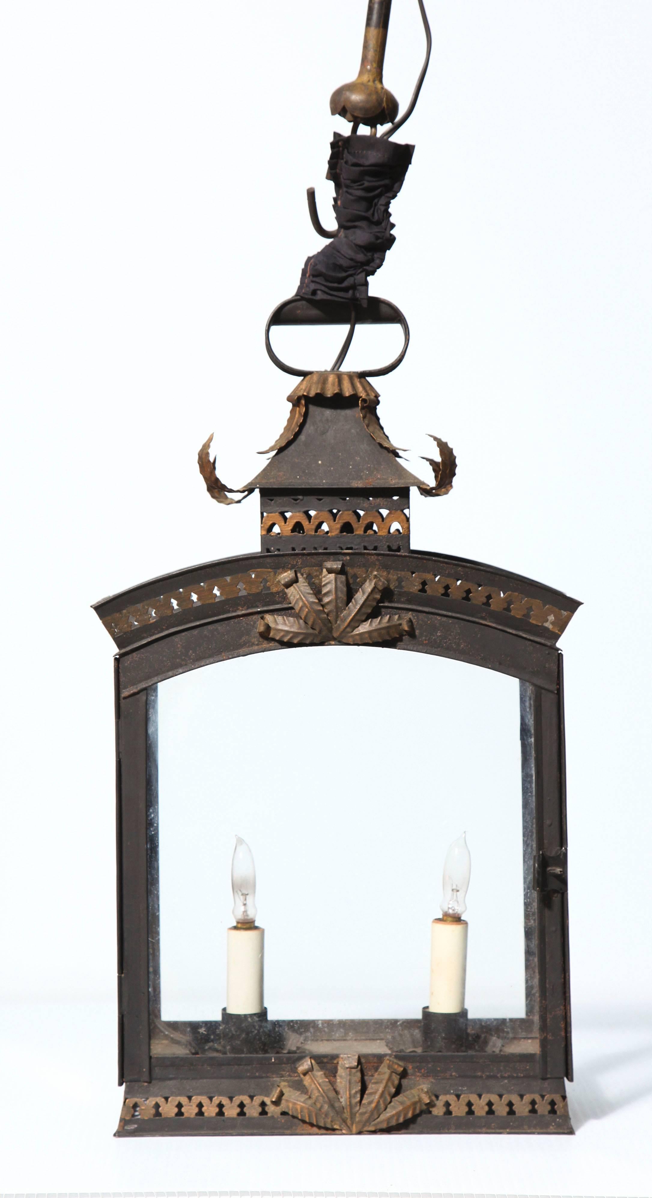 A charming and sophisticated two-light tole lantern in a painted and
gilded finish; with acanthus leaf detail, pagoda top and pierced gallery. 
New wiring required.
 