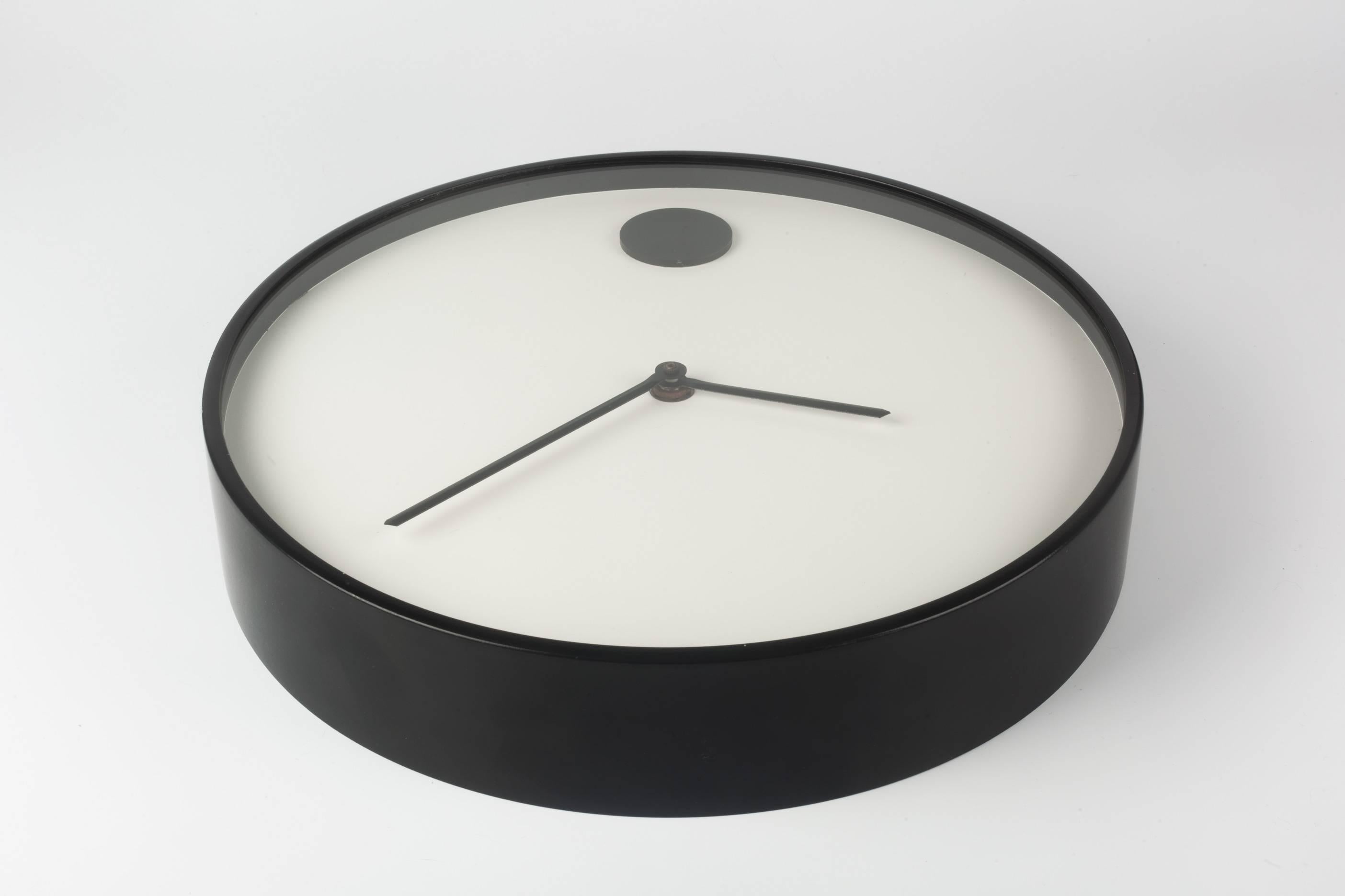 White wall clock with black metal frame, part of the MoMA design collection, 1970. Designed by Nathan George Horwitt for Howard Miller. Metal lacquered case and glass front. A wall clock version of Horwitt's previous watch design for Movado.

Nathan