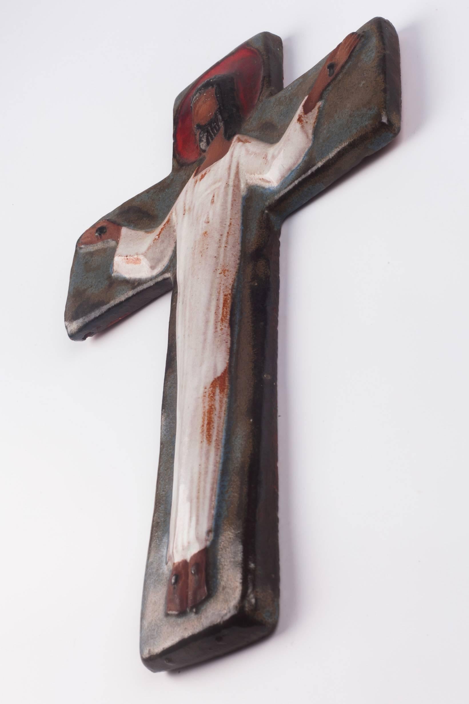 Large wall cross in ceramic, nearly ten inches tall, handmade in Belgium in the 1970s. Hand-painted in brown with hues of blue, white, and red. 

This piece is part of a 69-piece ceramic crucifix collection, all handmade in Belgium between the