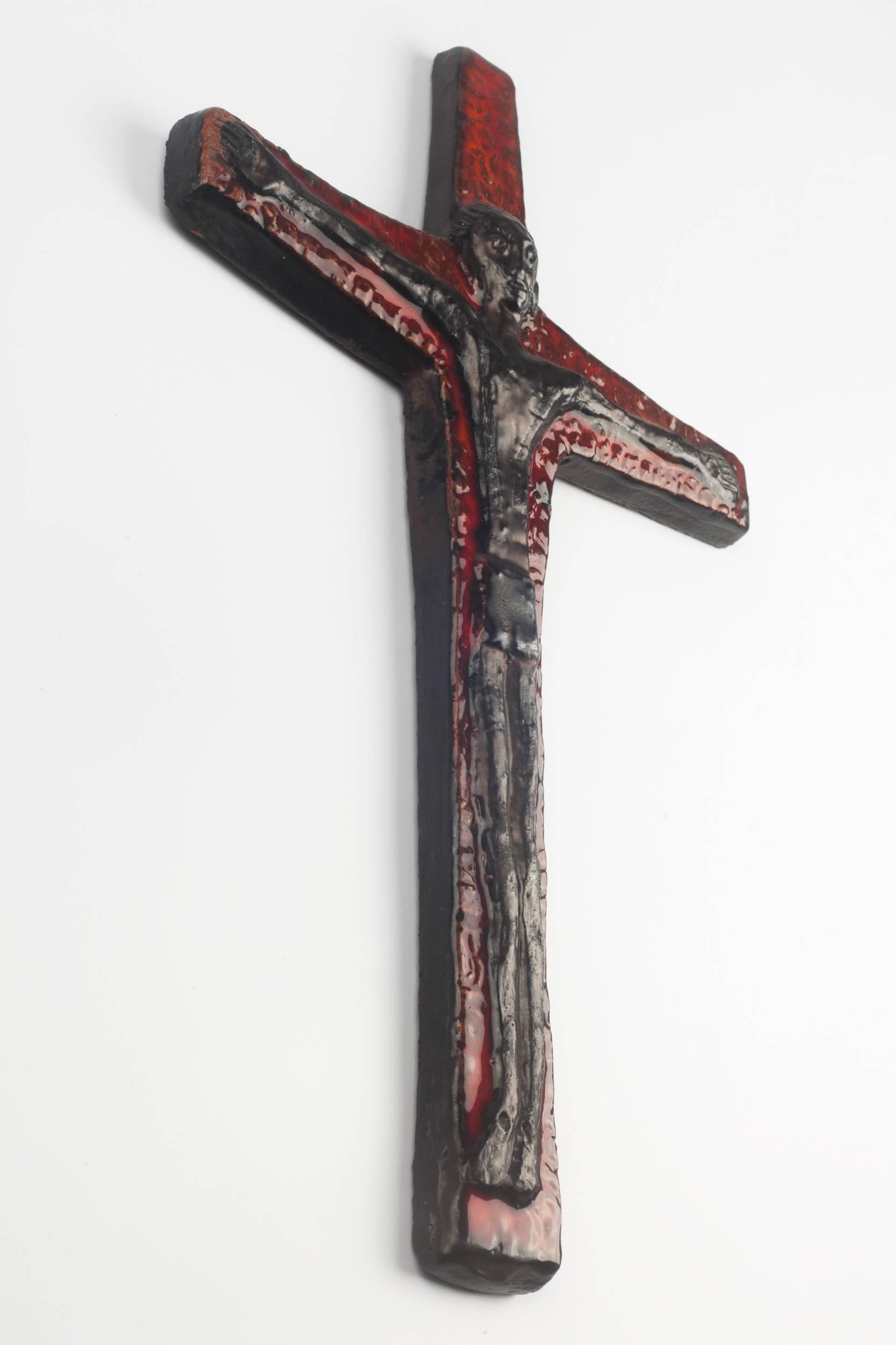 Twelve inch tall wall crucifix in ceramic, made in Belgium in the 1950s.
Black figure on dark Red Cross. Brutalist volumes.

This piece is part of a 69 piece ceramic crucifix collection, all made in Belgium between the 1950 and late 1970s. From