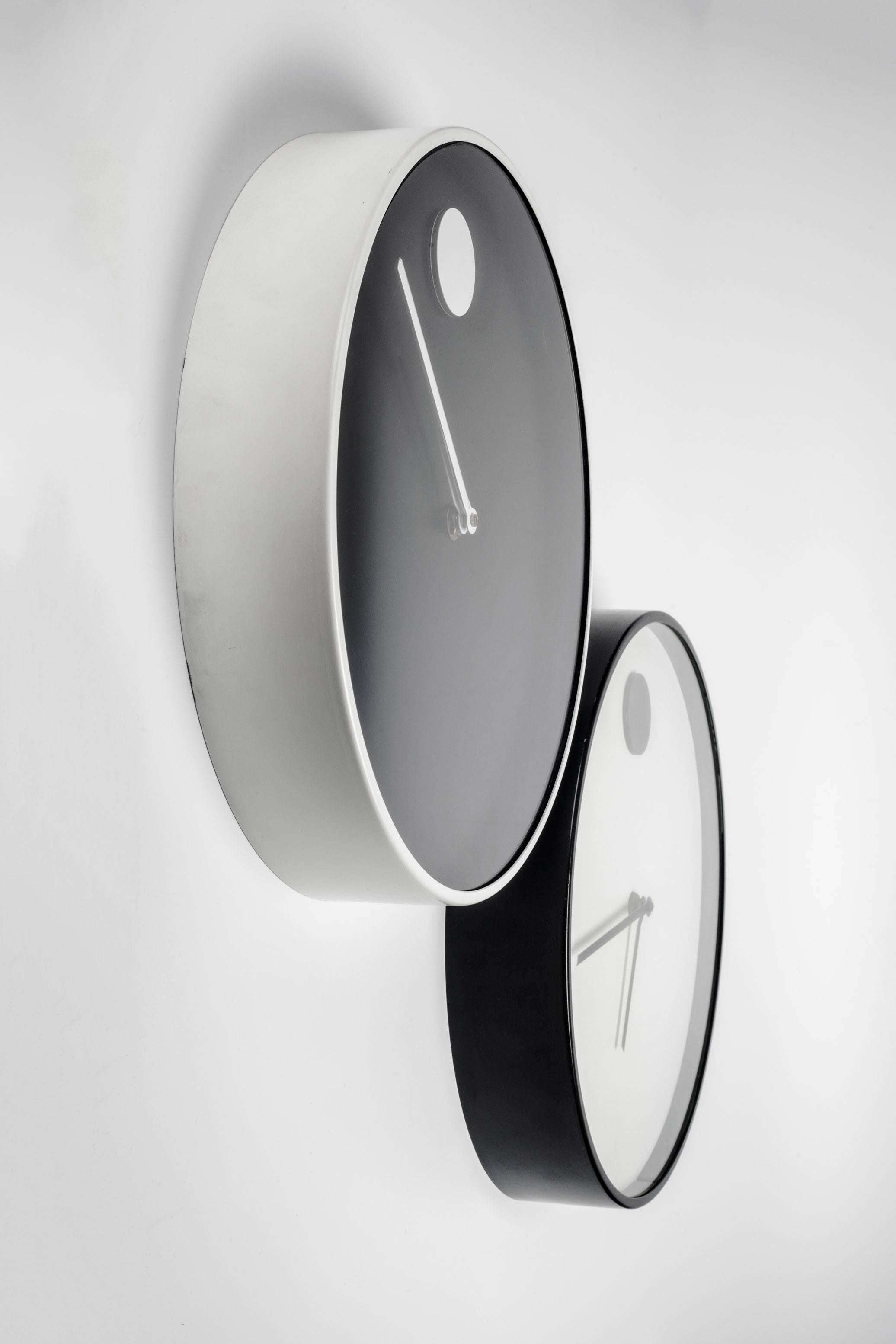 Black wall clock with white metal frame, part of the MoMA design collection, 1970. Designed by Nathan George Horwitt for Howard Miller. Metal lacquered case and glass front. A wall clock version of Horwitt's previous watch design for Movado.

Nathan