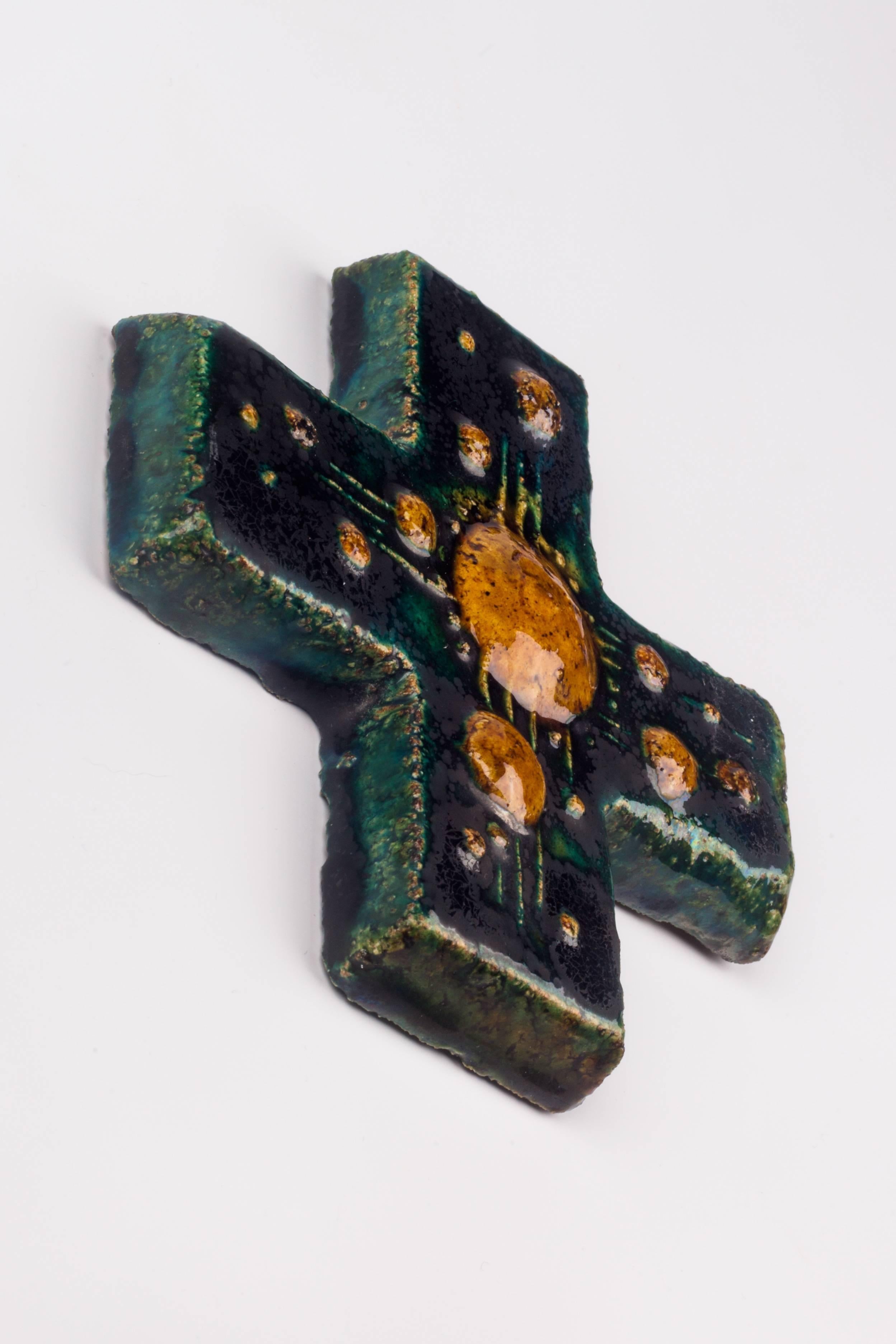 Wall cross in ceramic, made in Belgium in the 1970s.
Hand-painted, glossy blue-green cross with decorative brown circles and cross hatch in volume. 

This piece is part of a 69 piece ceramic crucifix collection, all made in Belgium between the 1950