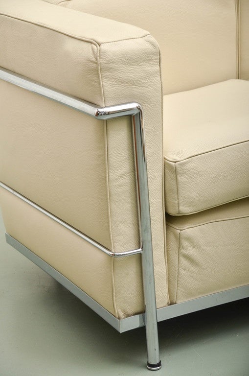 Beautiful soft cream leather two-seat sofa that sits on a chrome frame.