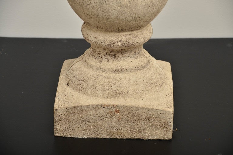 Pair of shaped column form on square bases, topped with square capital. Made of cast stone.