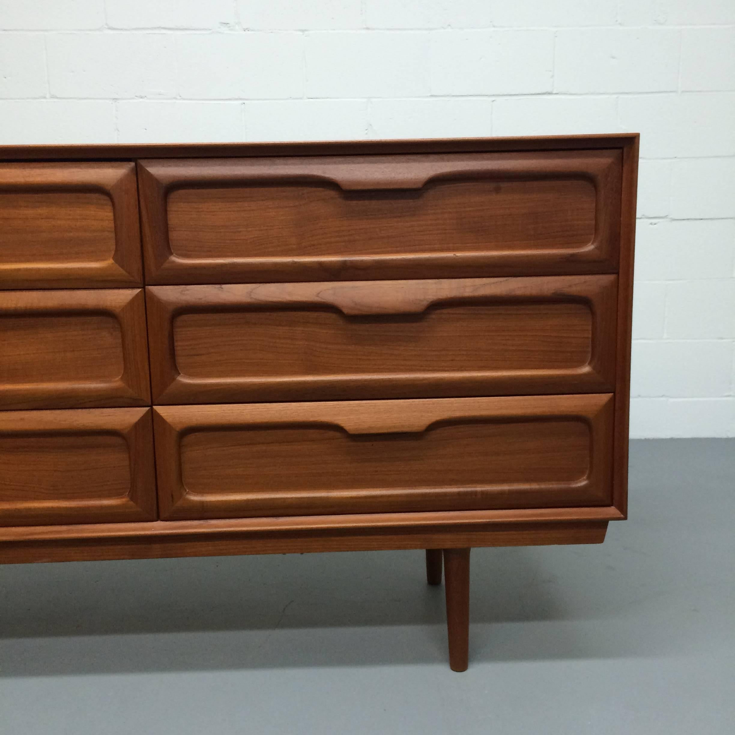A wonderful Mid-Century Modern long dresser/ credenza/ sideboard made of teak. This piece, which has had only one owner, was purchased in 1963. It is in very good condition with minor age appropriate wear. There are nine drawers, three of which have