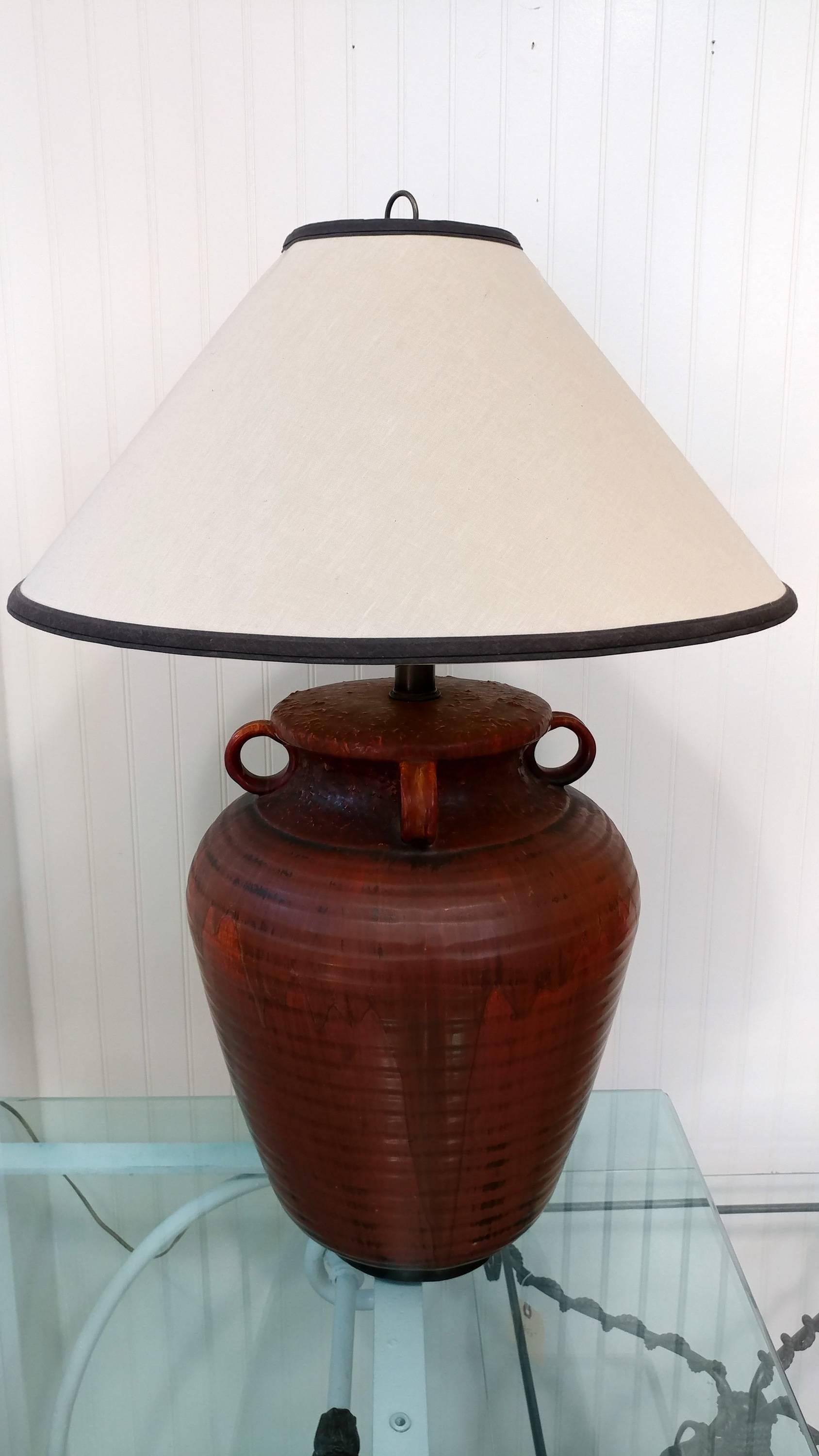 Very early and enormous skill hand thrown stoneware in an ovoid jar form table lamp by Nardini Studios. Beautiful earthy clay red matted drip glazed over incised body, 4 vertical handles. Circa 1950s, a fine and rare example of Nardini Studios