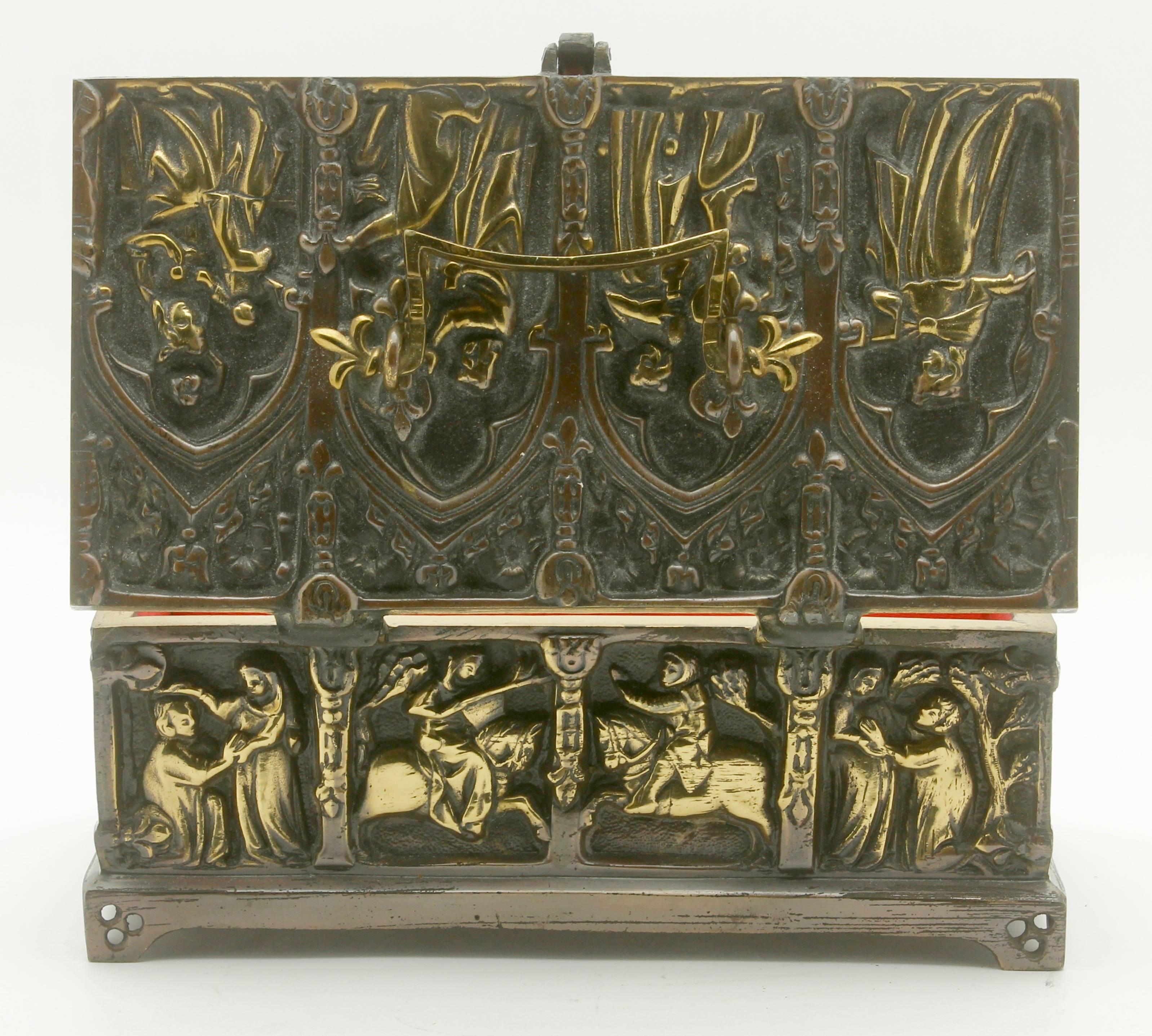 The top, front, sides and back are beautifully cast in gilt bronze and feature panels of medieval scenes of revellers hunting and feasting.
Good condition with typical marks and wear for an item of this age.
The interior is lined with red silk,