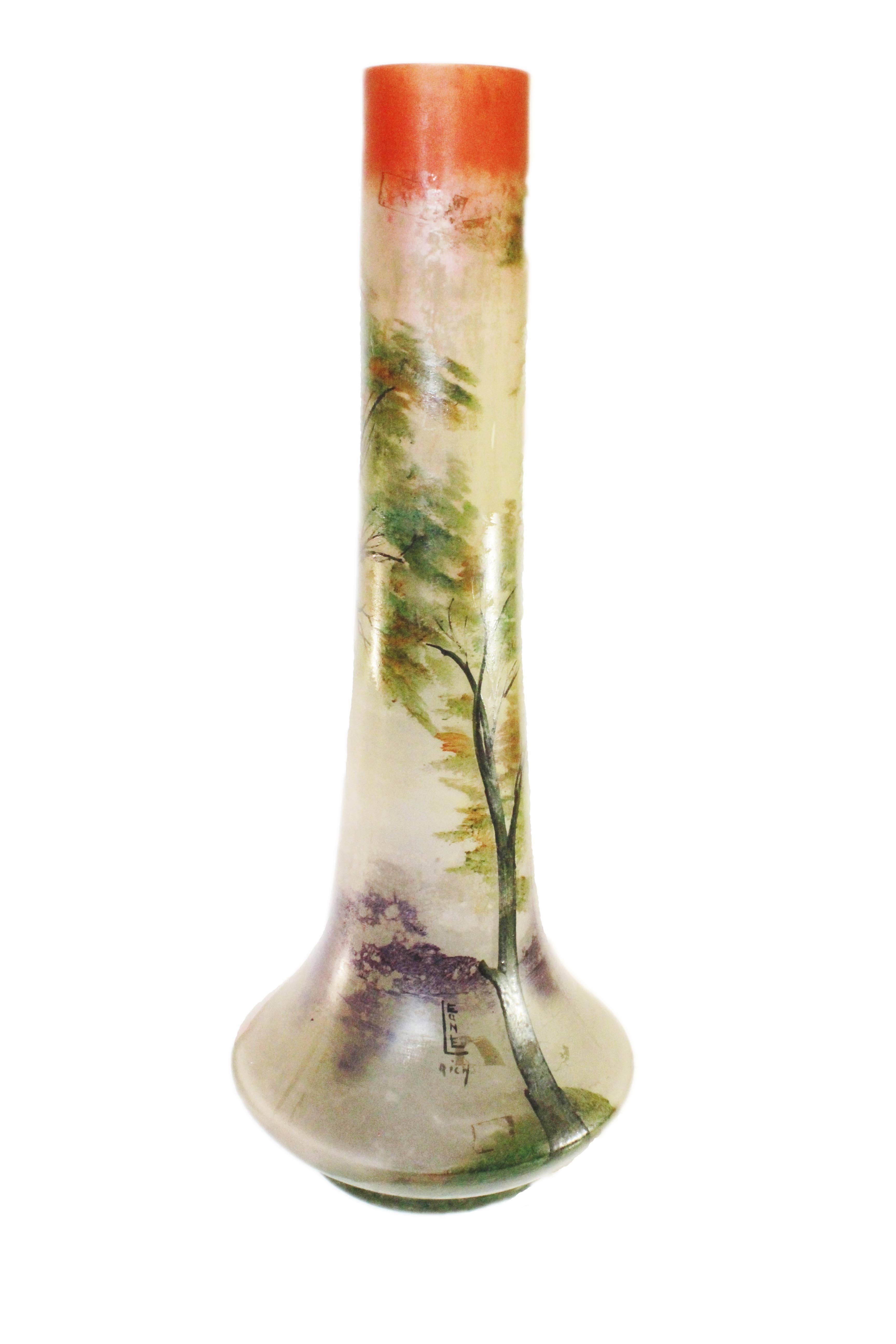 Signed Leune vase 19.5 cm high and 25 cm wide made of matted glass, decorated with a hand-painted enamel decoration. The decoration on the vase consists of an orange sunset (this is simulated by the neck) above a forest landscape in autumn colors.