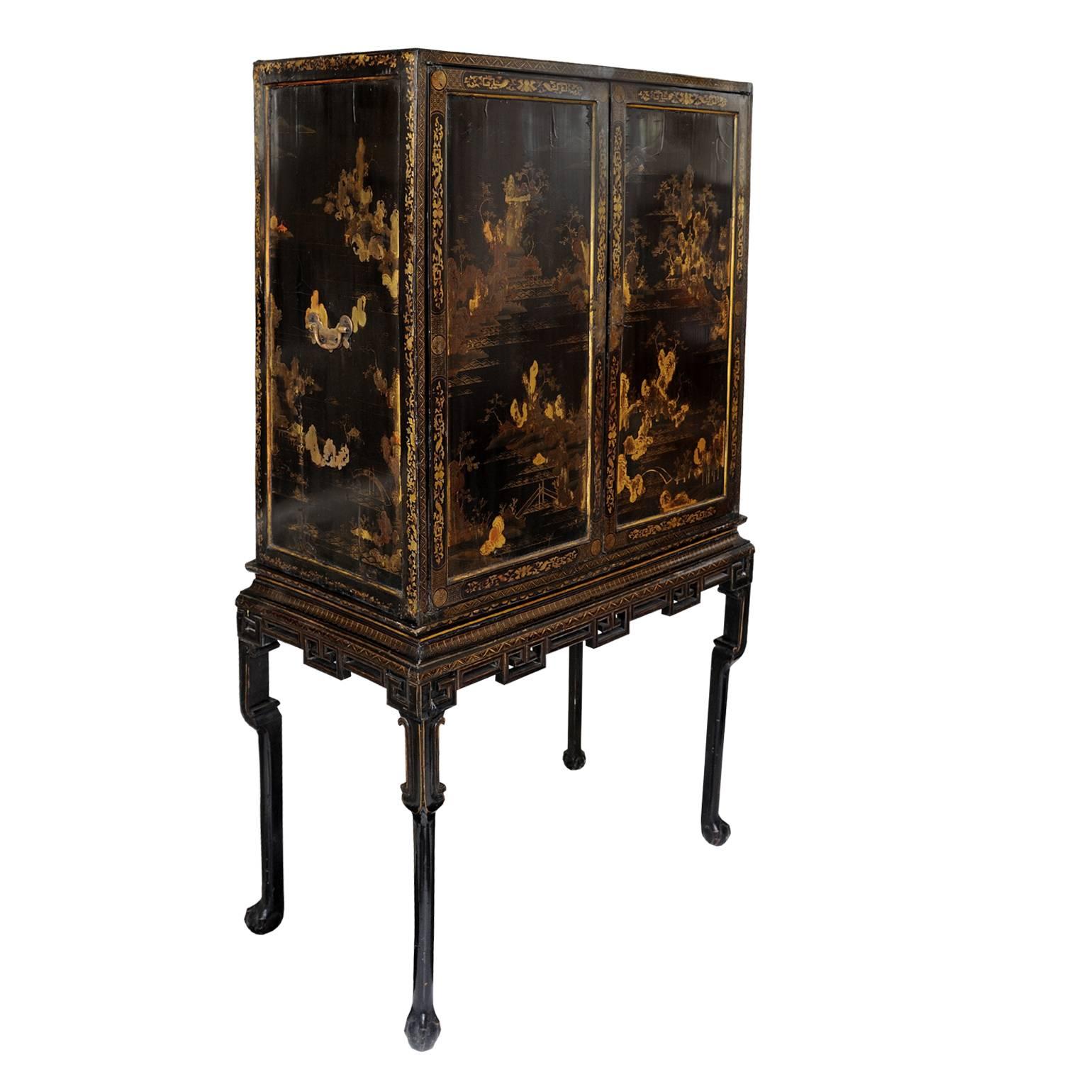 This is a rare and beautifully proportioned Chinese export George II lacquered cabinet on stand, featuring a wonderfully decorated and fully fitted interior consisting of two main lower drawers and 17 smaller draws above, circa 1740.