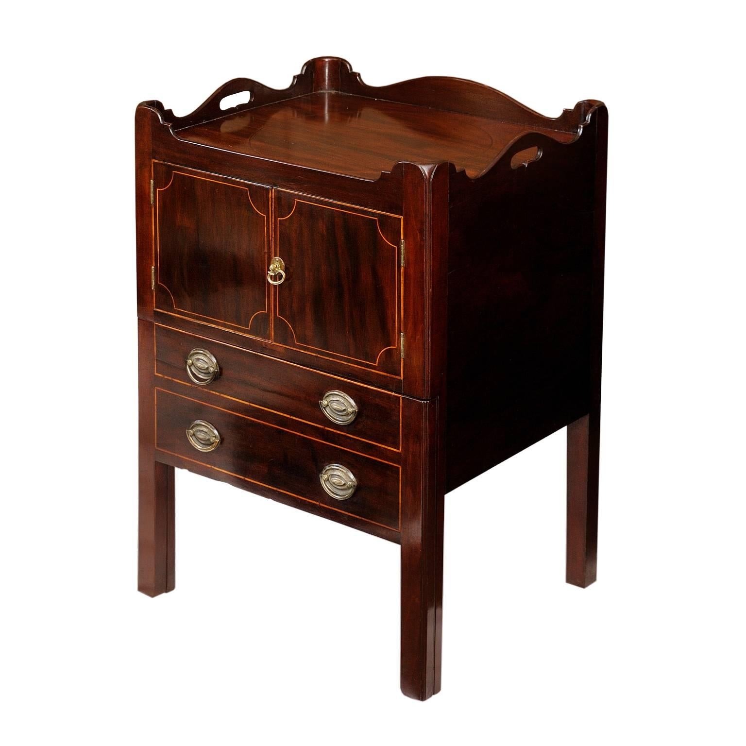 This is a rather lovely English late 18th century George III mahogany tray top commode or bedside Table. The commode has a pull-out drawer below with a cupboard situated above and is finished with boxwood stringing inlay detail and beautiful brass