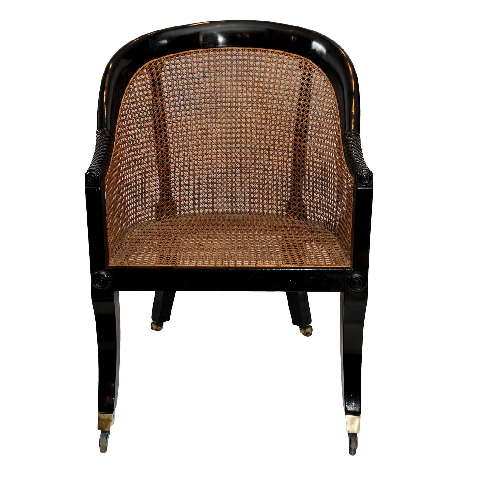This is a very nice example of an English early 19th century Regency ebonized library chair, with stylish sabre legs and brass square cup castors. The cane work is in very good condition, circa 1810.
 