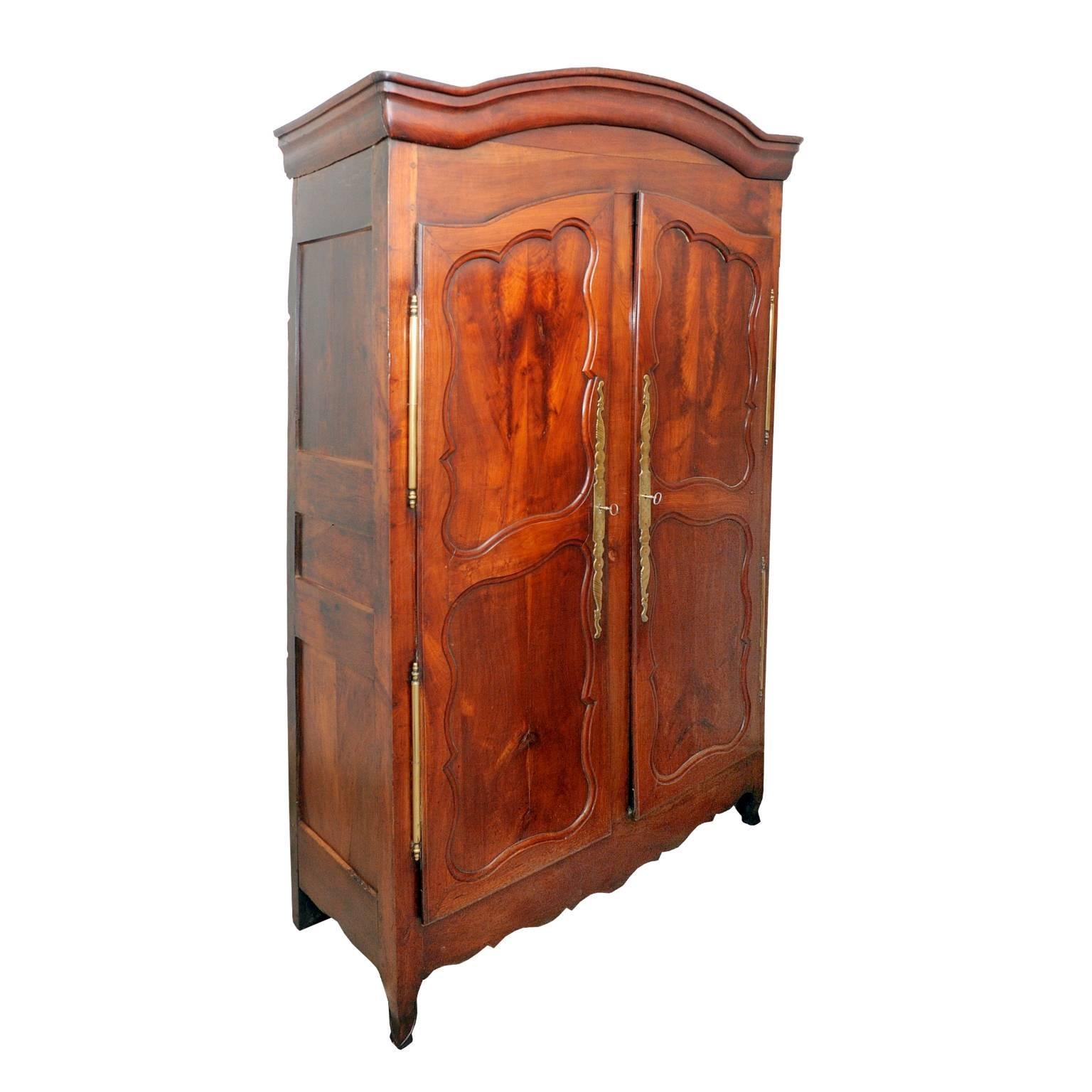 This is a rather beautiful tall French mid-18th century Louis XV cherrywood armoire cupboard with bonnet top, decorative shaped panels and original brass door furniture and locks. Fitted interior, including three fixed shelves and a single