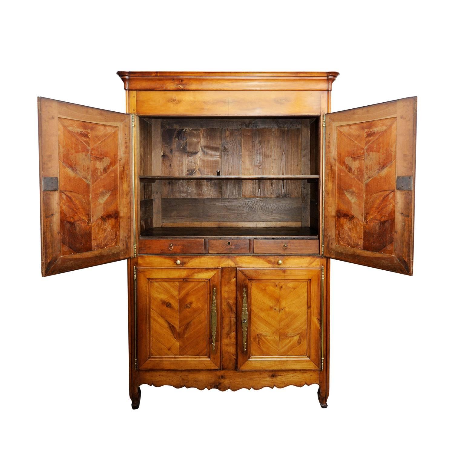 This is a rare and beautifully proportioned French, mid-18th century, Louis XV period four-door cheerywood Armoire Cupboard with chevron panels and original brass escutcheons and long barrel hinges. Pair of half drawers to centre and fitted drawers